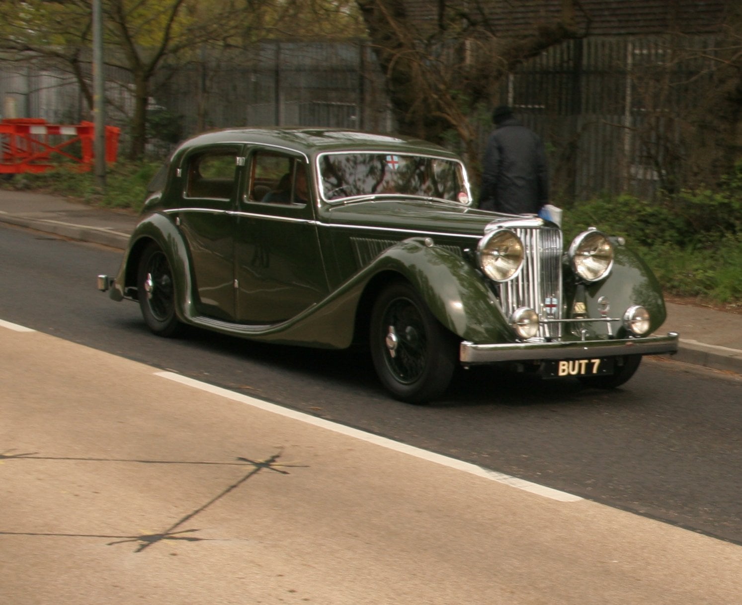 A dark green SS Jaguar 2.5-litre saloon of 1939 on grass, front three-quarter view, UK registration BUT 7