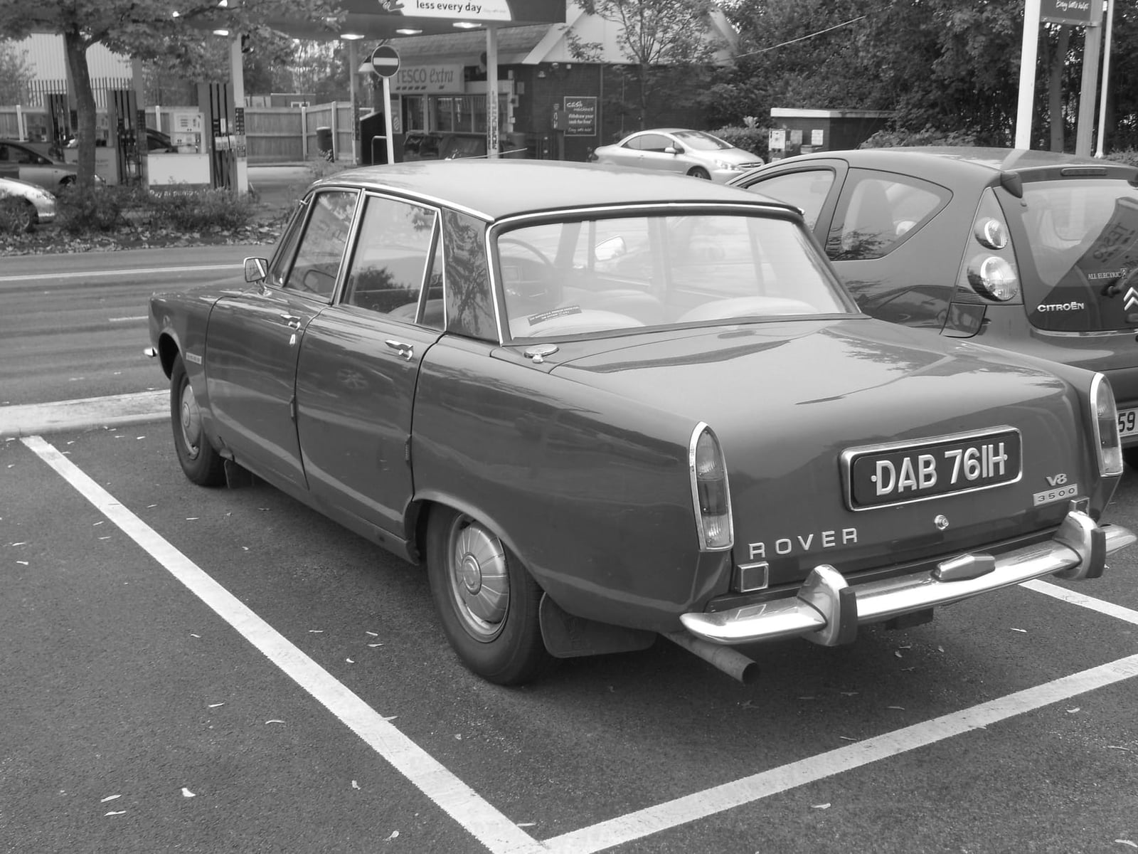 A black and white photograph of a Rover P6 parked in a car park, rear three-quarter view, UK registration DAB 761H