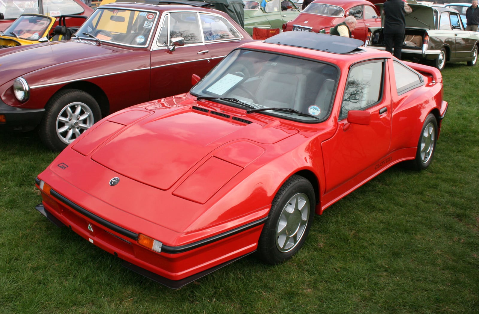 A red Clan Clover, a mid-engined wedge-shaped coupe, photographed from the front