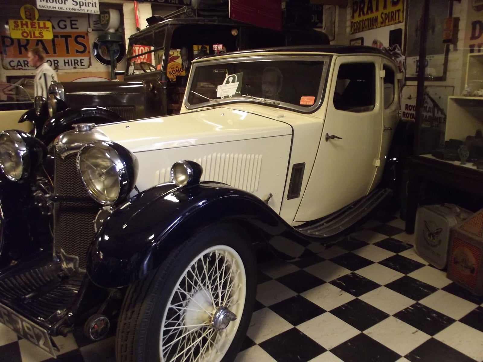 A cream and blue 1934 Riley Kestrel on display in a motoring museum
