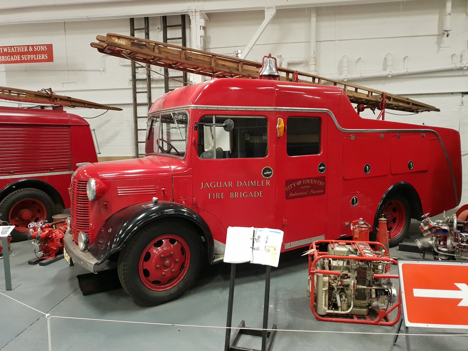 A red locally built fire engine on display inside Coventry Transport Museum