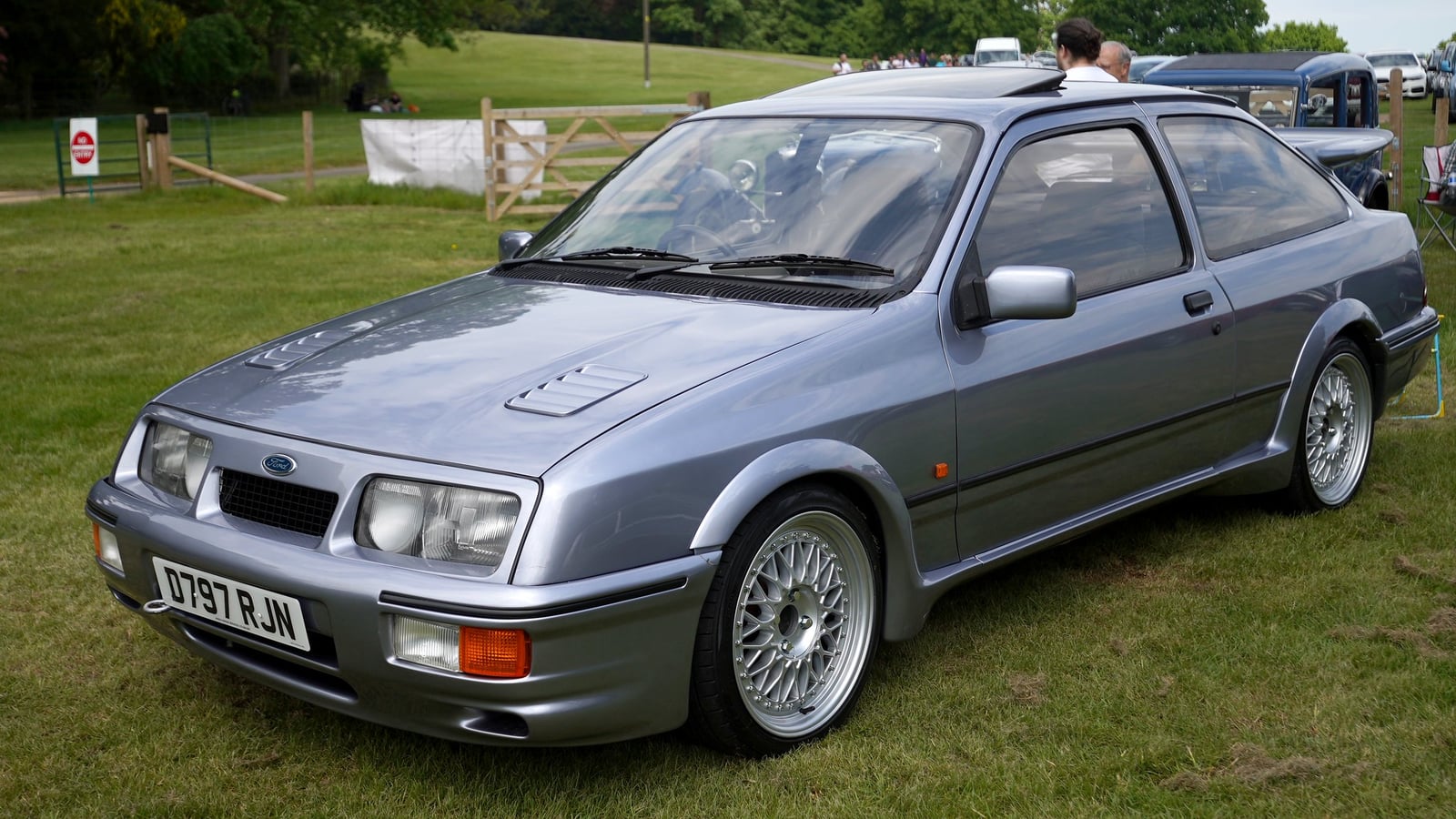 A grey three-door Ford Sierra RS Cosworth on grass, front three-quarter view