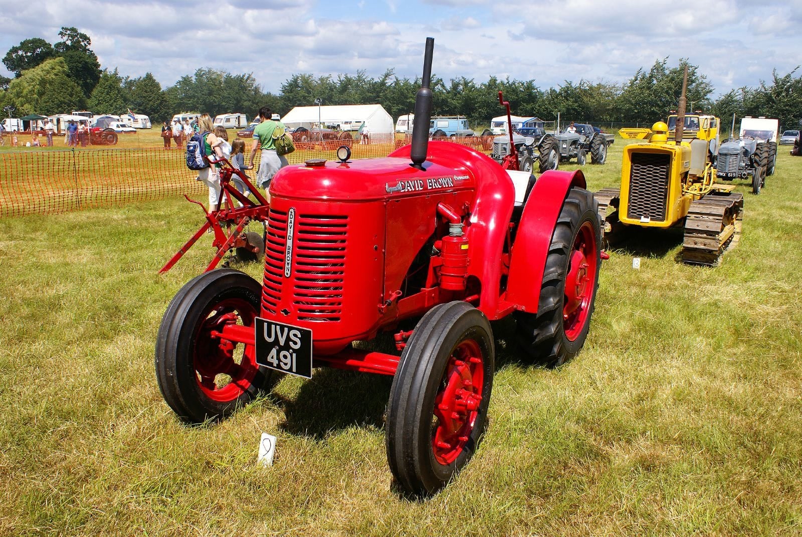 A red vintage David Brown tractor at a country fair, UK registration UVS 491