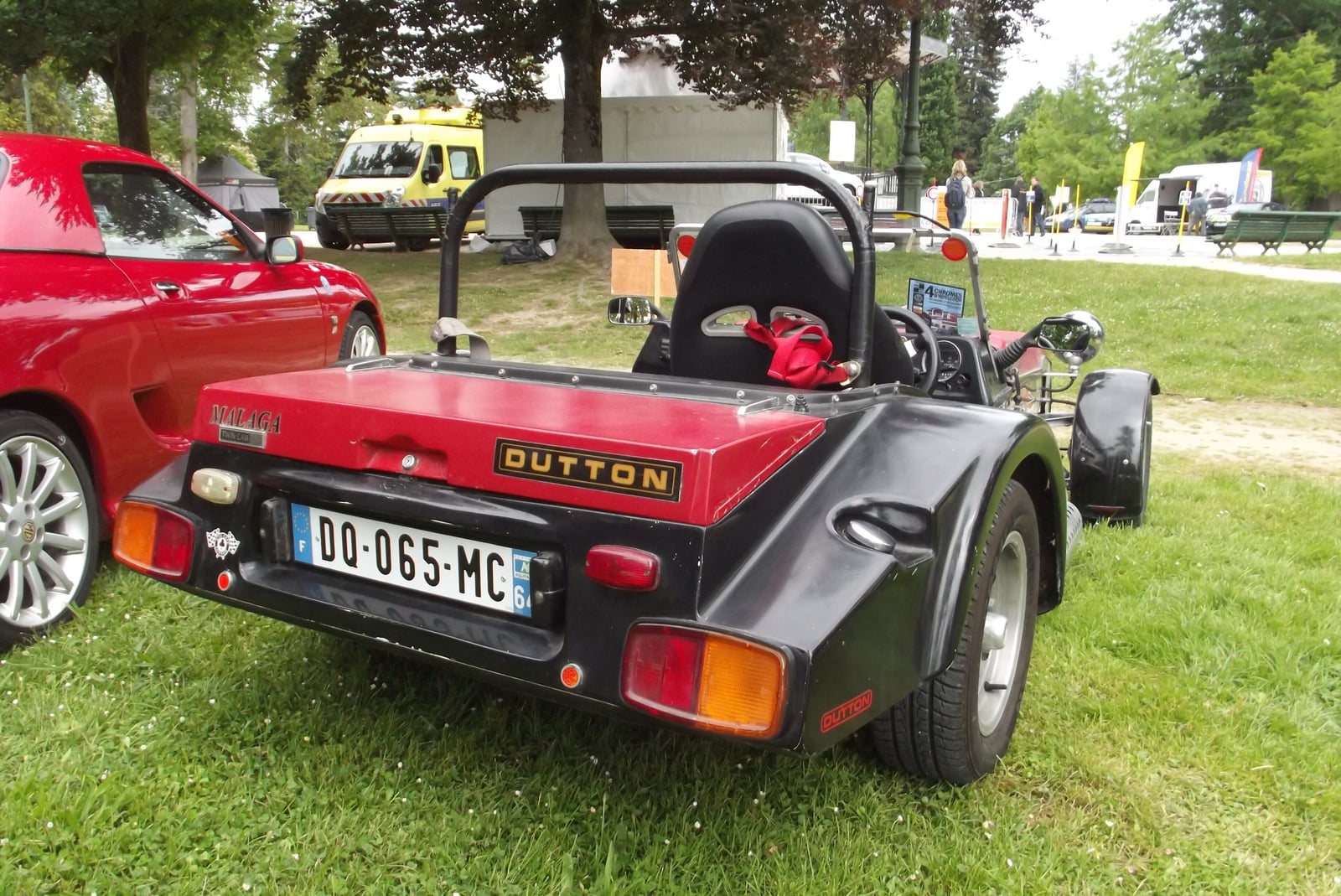 A red Dutton Malaga open roadster seen from the rear, with the Dutton name on the rear panel, registration OB 985 NC