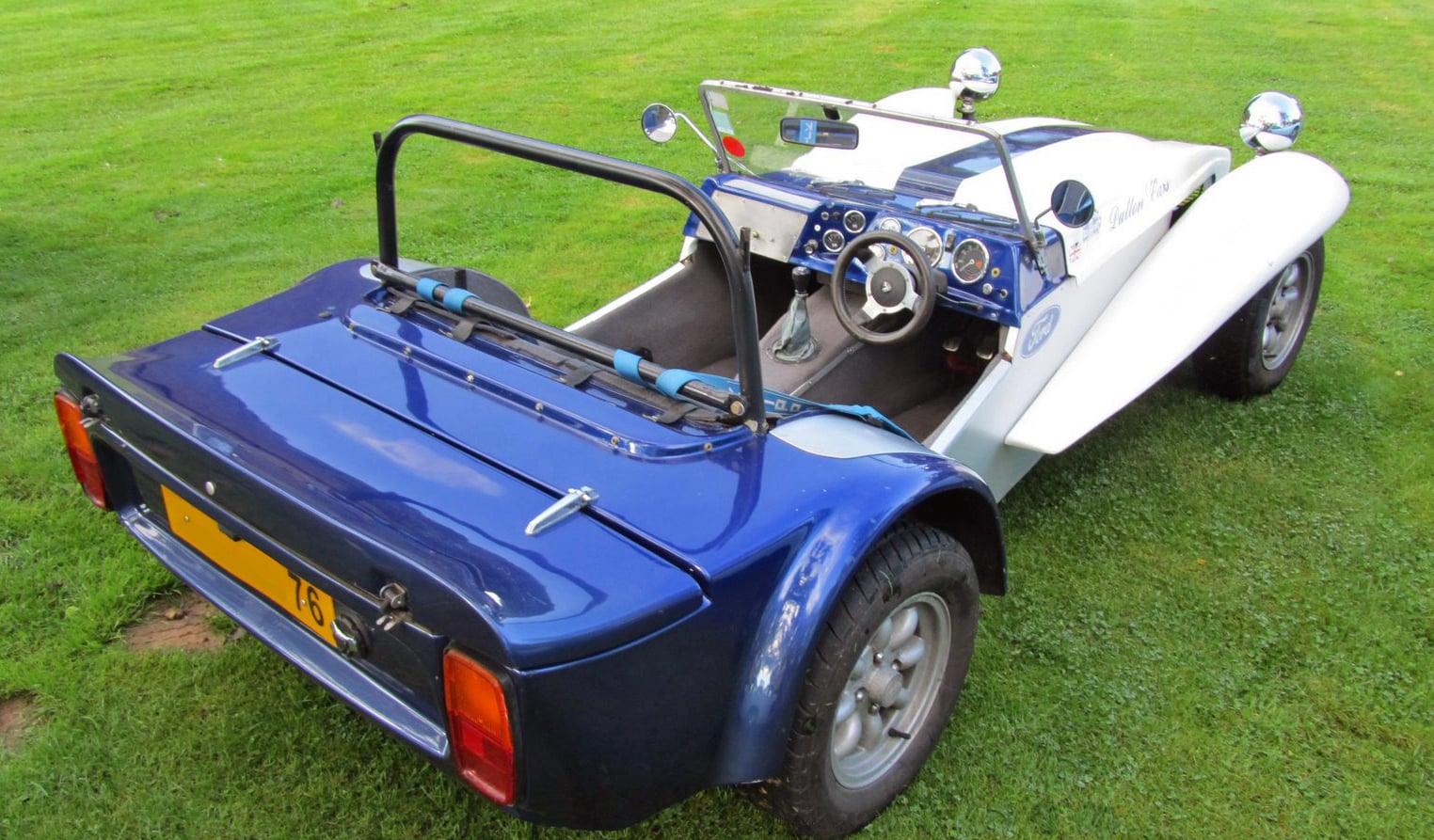 A yellow Dutton Phaeton photographed from the rear on a road
