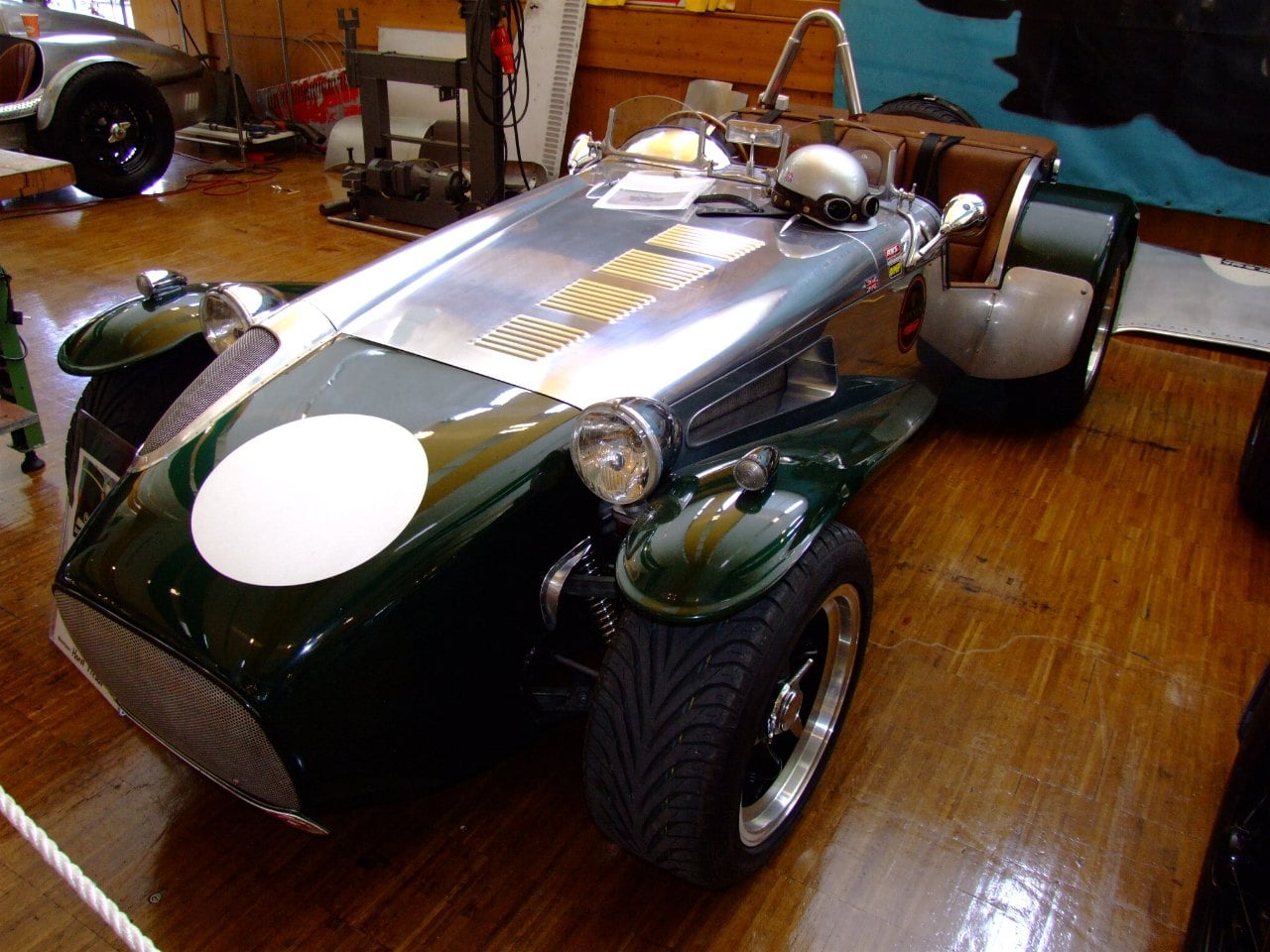 A yellow Dutton open roadster with cycle wings, registration JF 4501, side view on grass at a classic car show