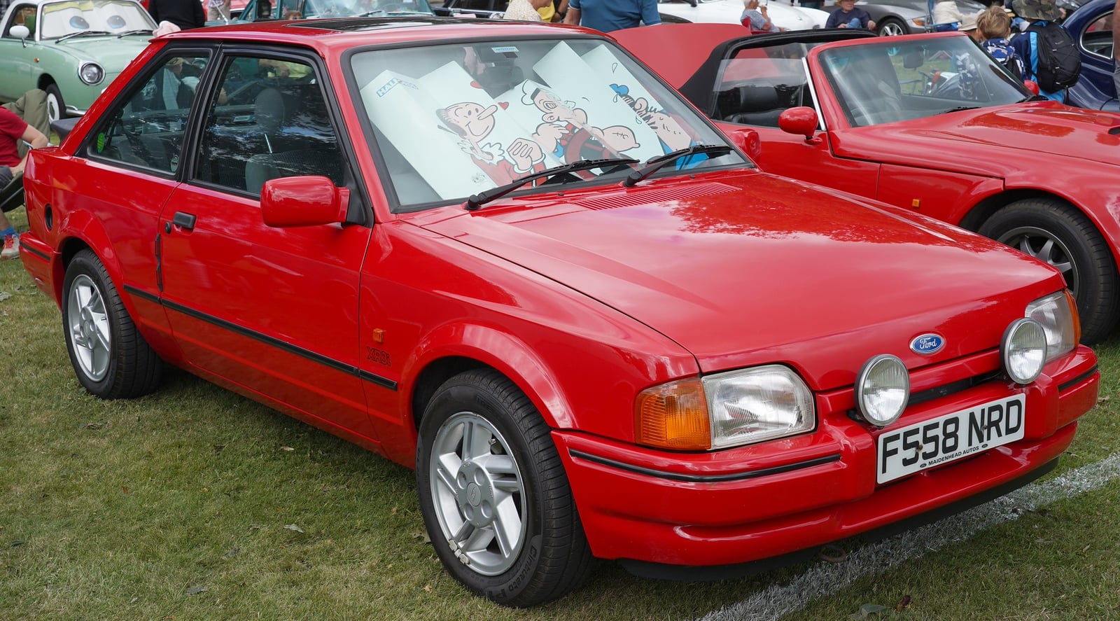 A red Ford Escort XR3i hatchback at a show, front three-quarter view
