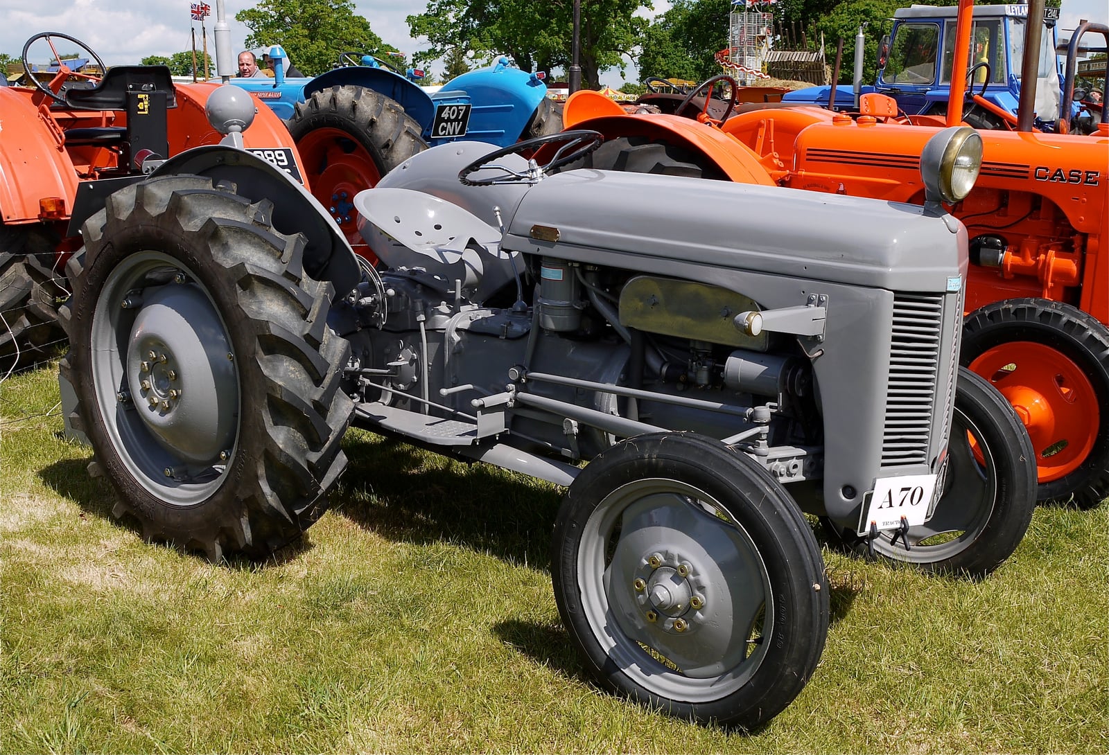 A restored grey Ferguson TE20 on show, side-front view, lined up with other classic tractors