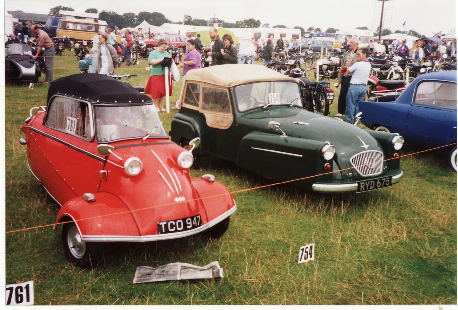 A red Messerschmitt beside a green Bond Minicar on a showfield