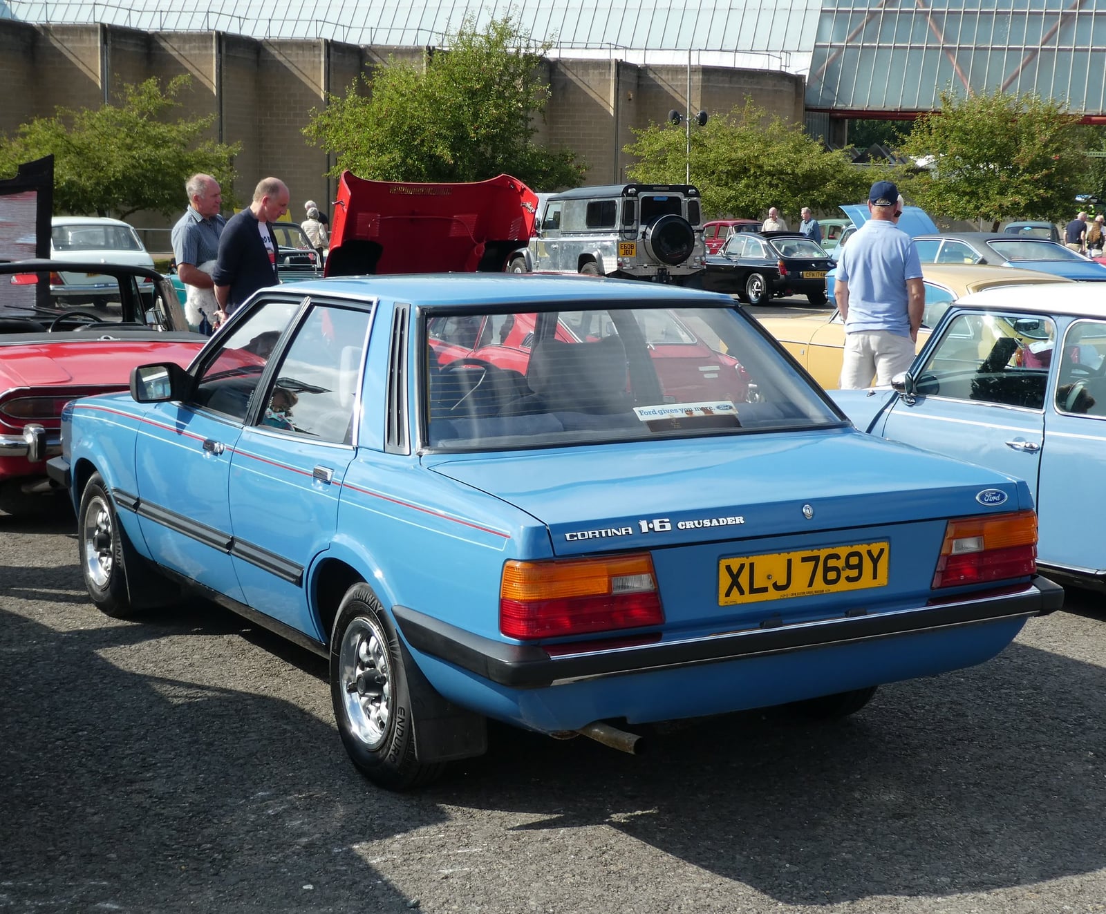 A blue 1982 Ford Cortina Crusader four-door saloon, rear three-quarter view at a classic car show, the Cortina 1.6 Crusader badge visible on the boot