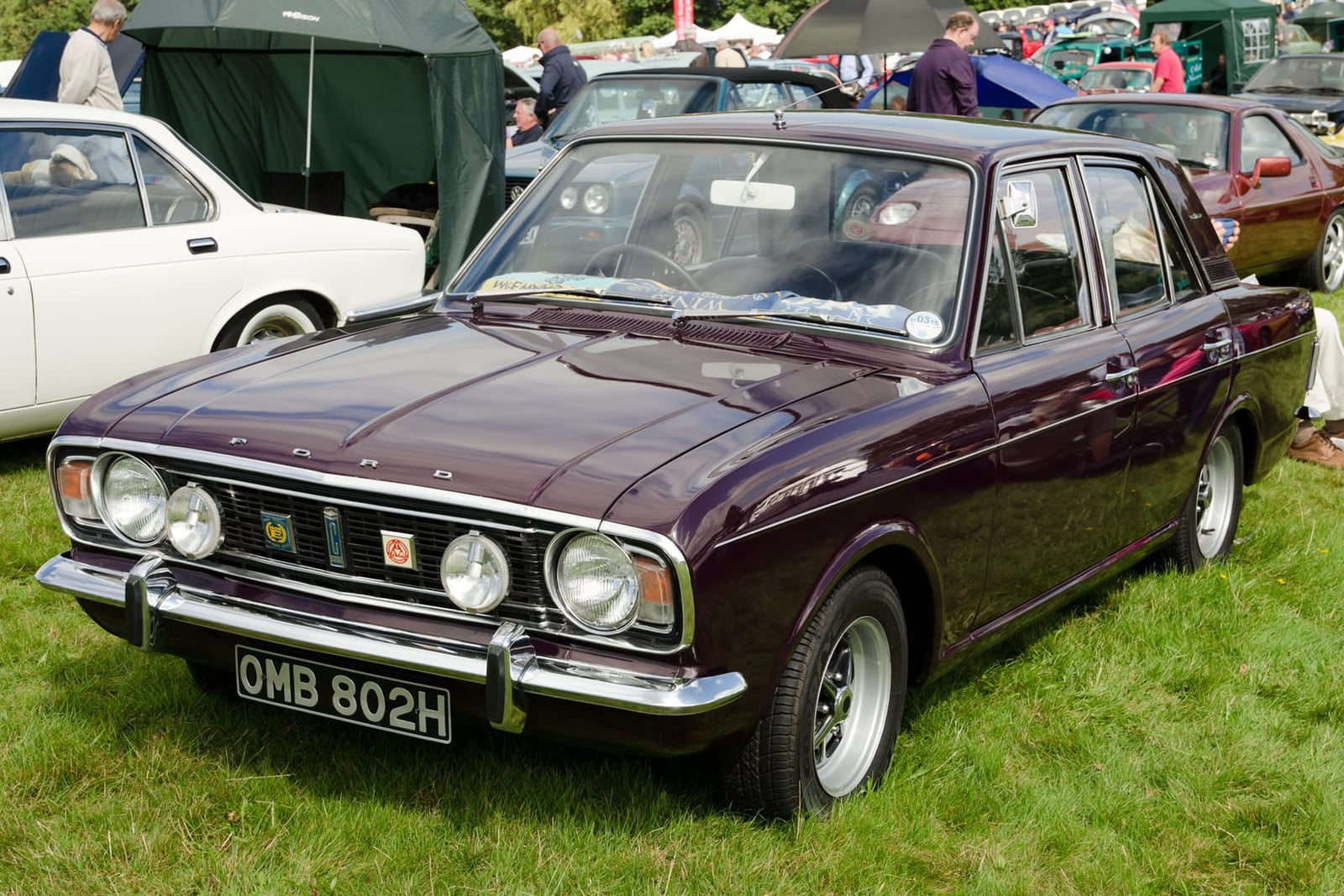 A maroon 1970 Ford Cortina Mk2 with a UK registration on a show field