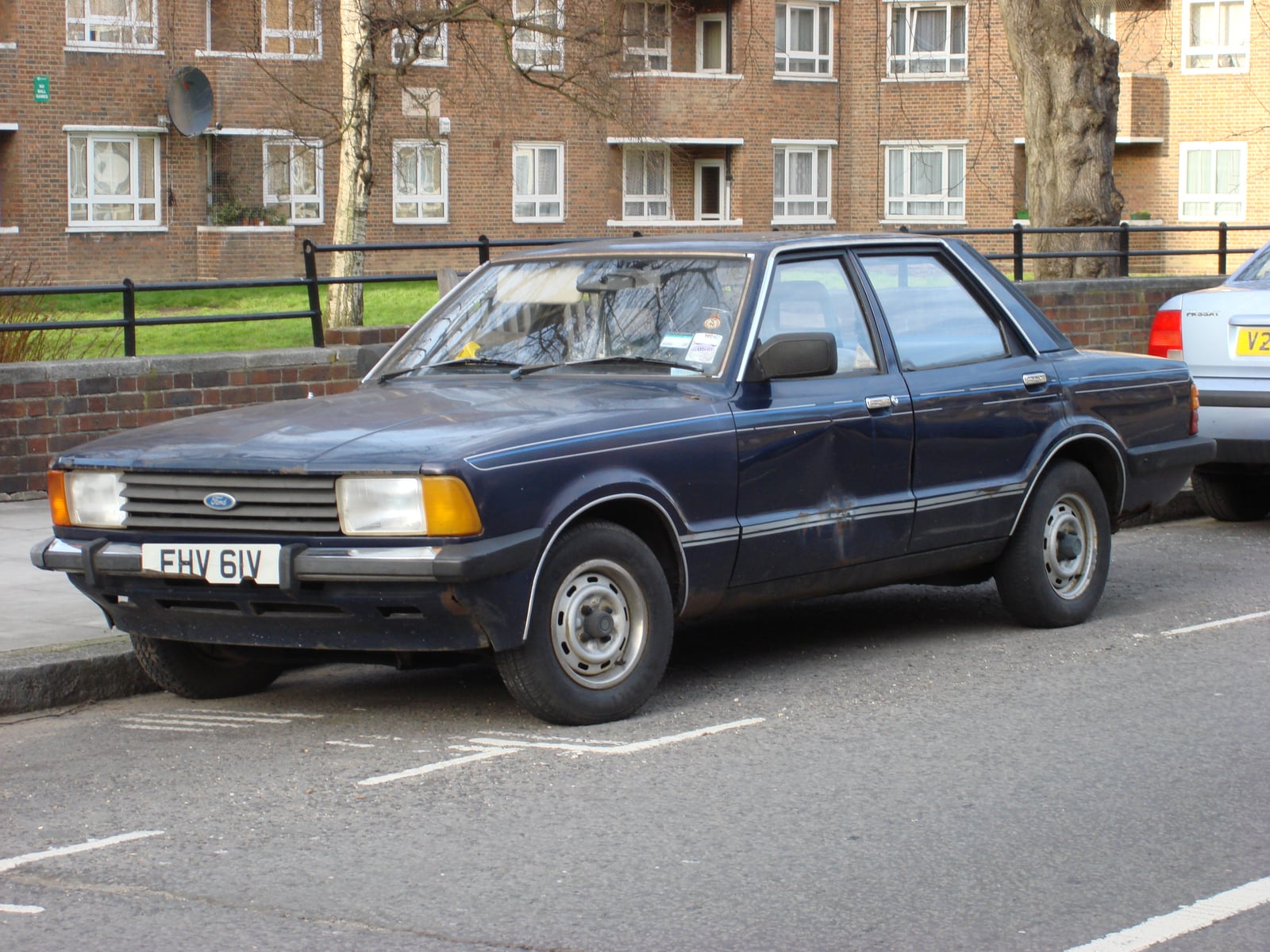 A dark blue Ford Cortina Mk4 four-door saloon on a street, front three-quarter view