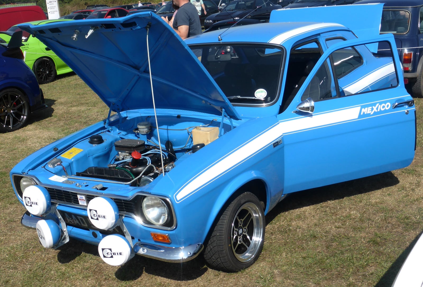 A blue Mk1 Ford Escort Mexico with the bonnet raised, showing the engine