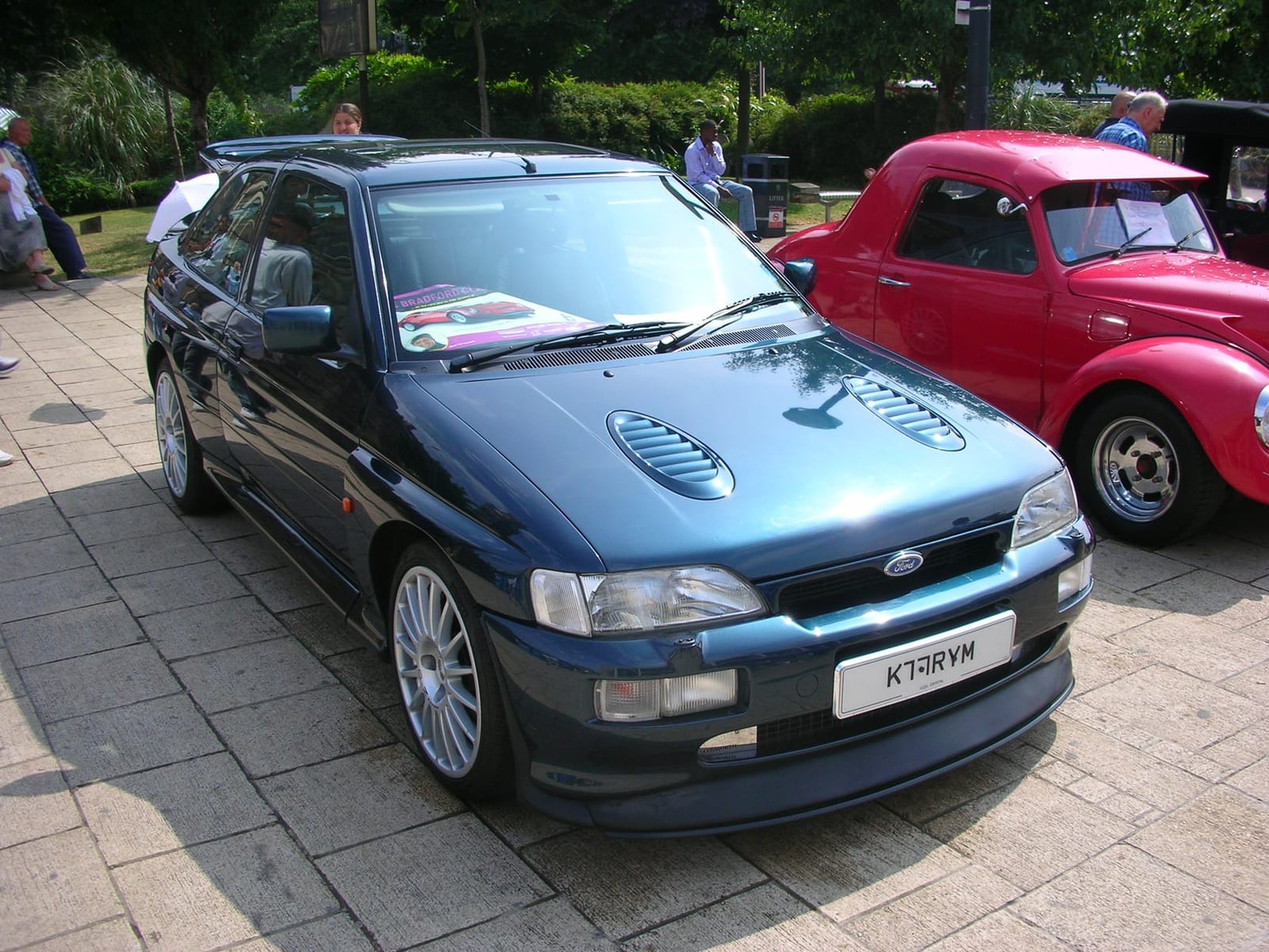 A blue Ford Escort RS Cosworth parked on a paved forecourt, front three-quarter view, UK registration K759 RVW