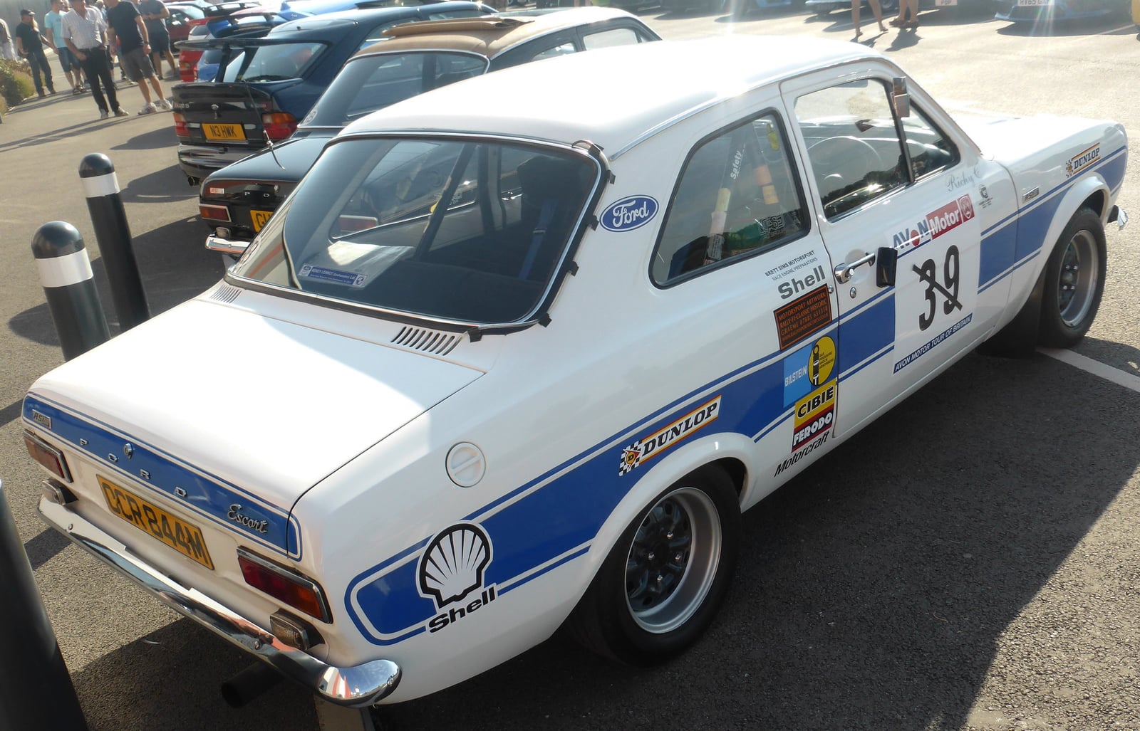 A white Mk1 Ford Escort RS2000 in period rally livery, rear three-quarter view