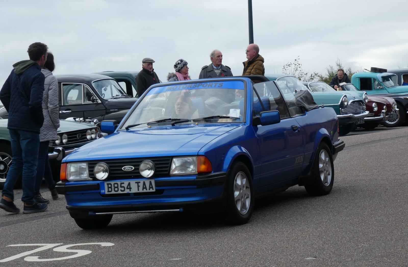 A blue early Ford Escort XR3i cabriolet with the top down, front three-quarter view
