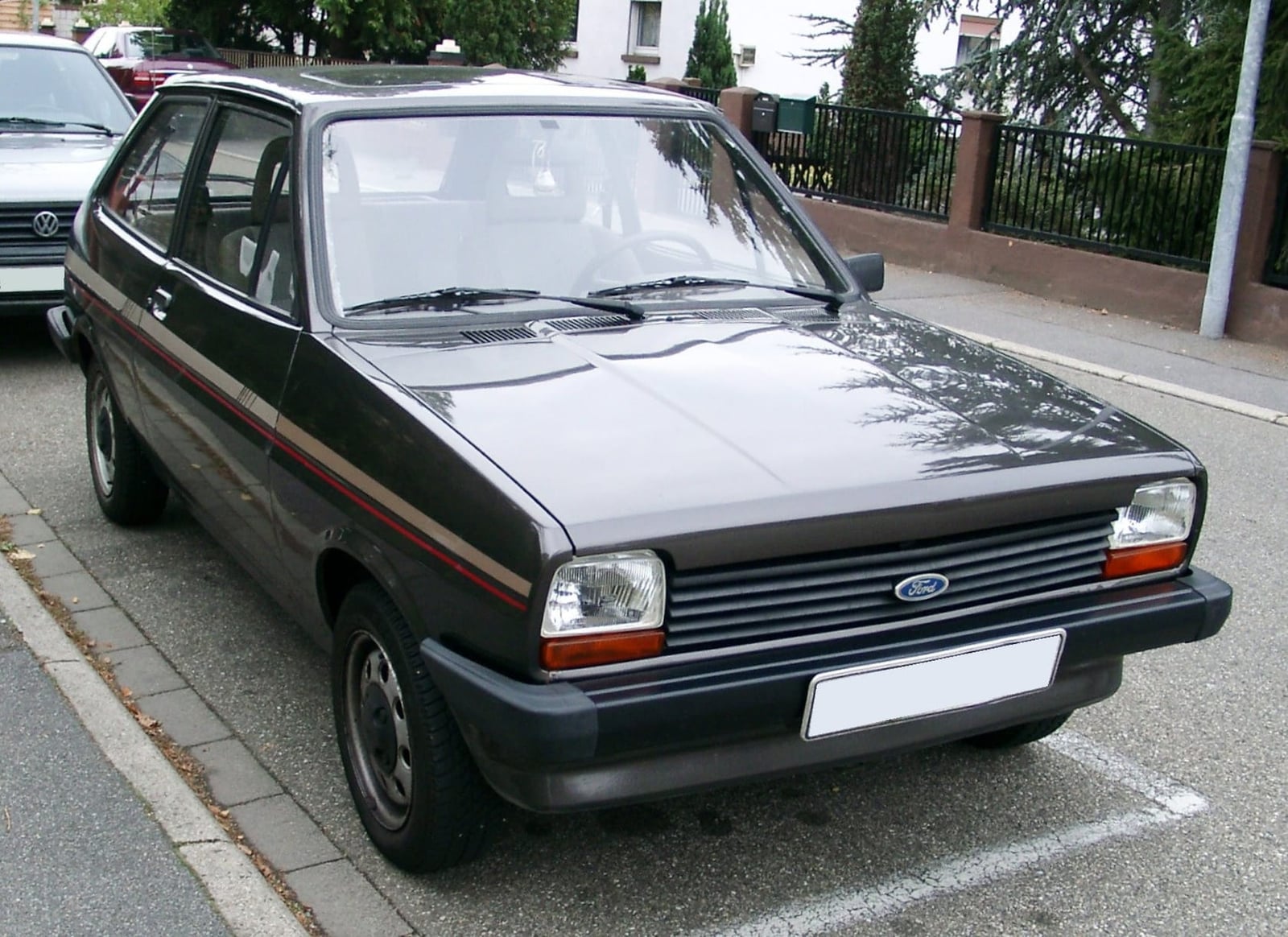 A black Ford Fiesta Mk1 parked at the kerb on a street, front three-quarter view
