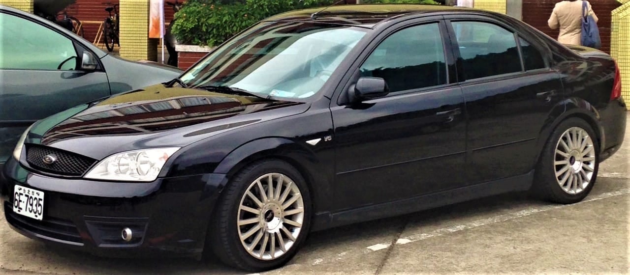 A black Ford Mondeo ST220 saloon parked on a street, side view