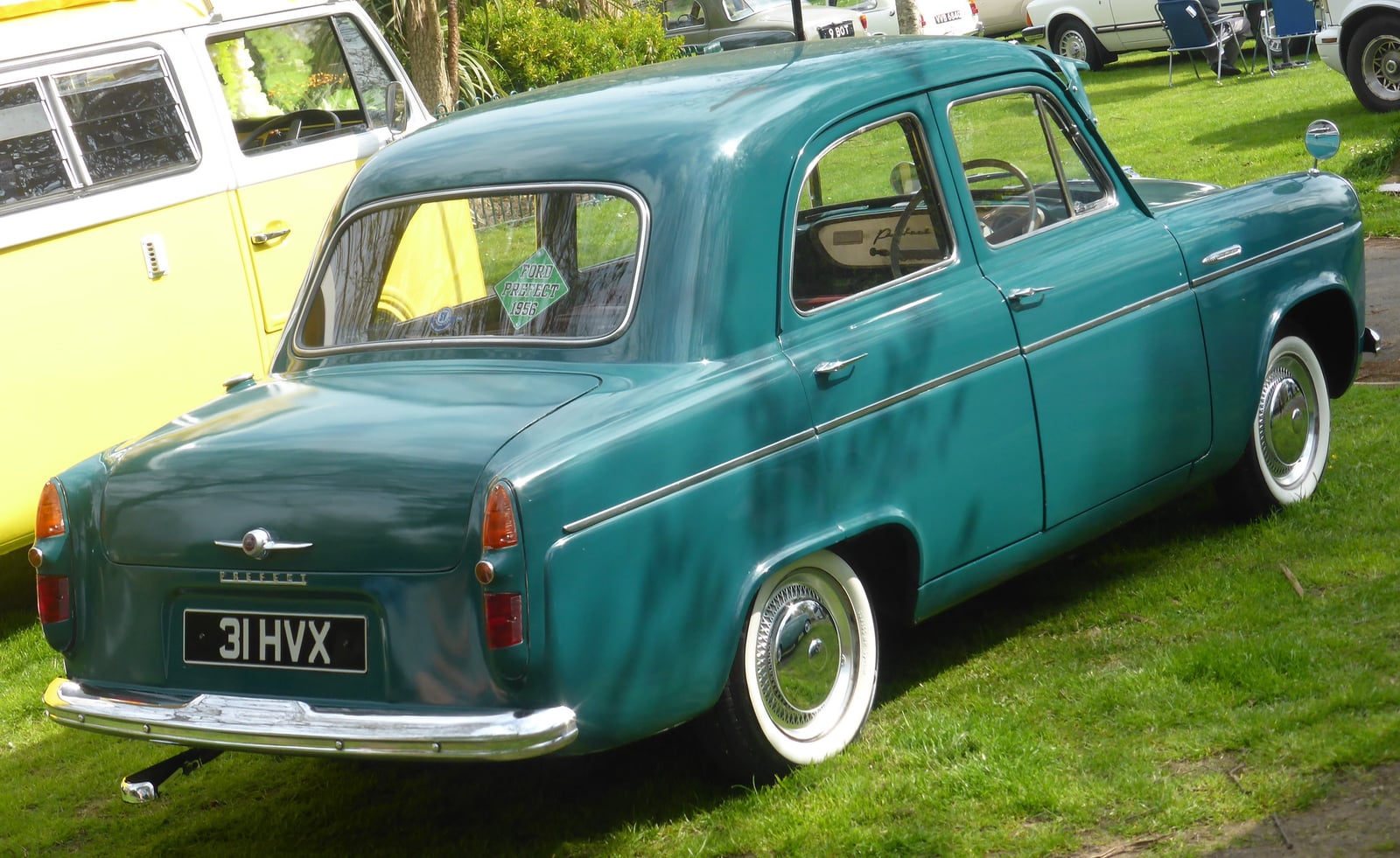 A teal Ford Prefect 100E saloon at a show, front three-quarter view
