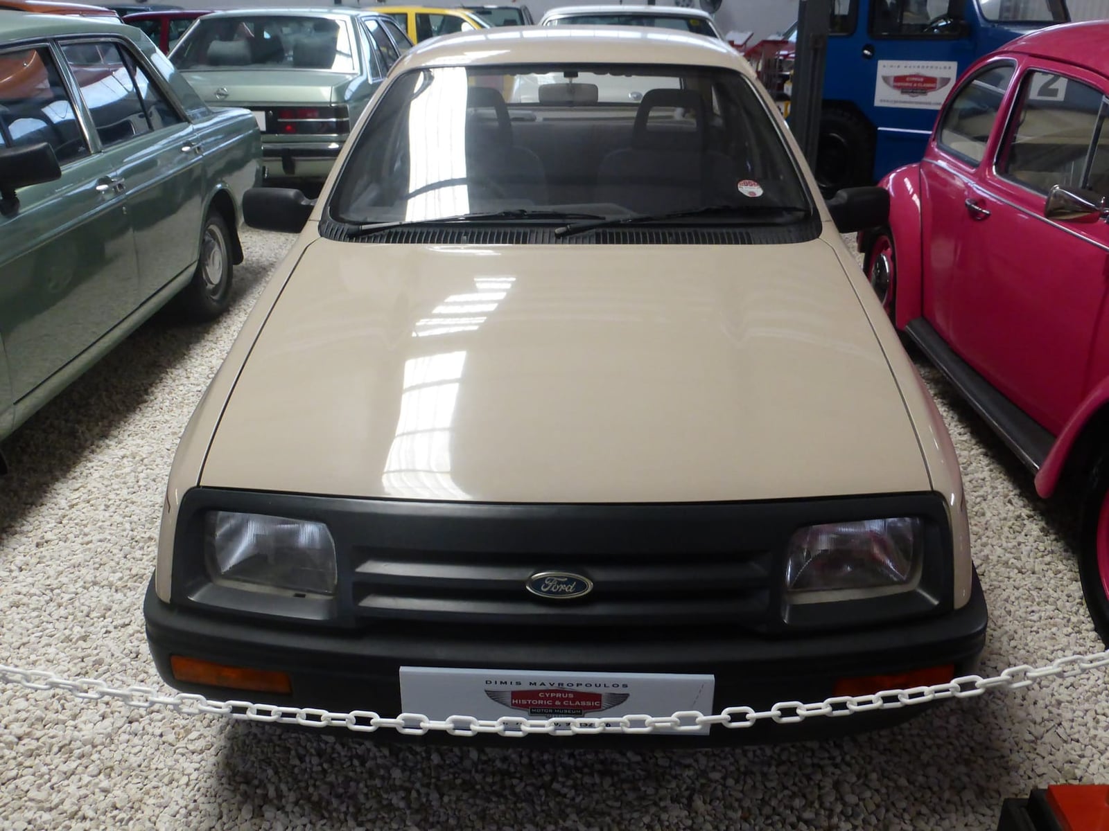 A beige 1983 Ford Sierra displayed in a museum, front view