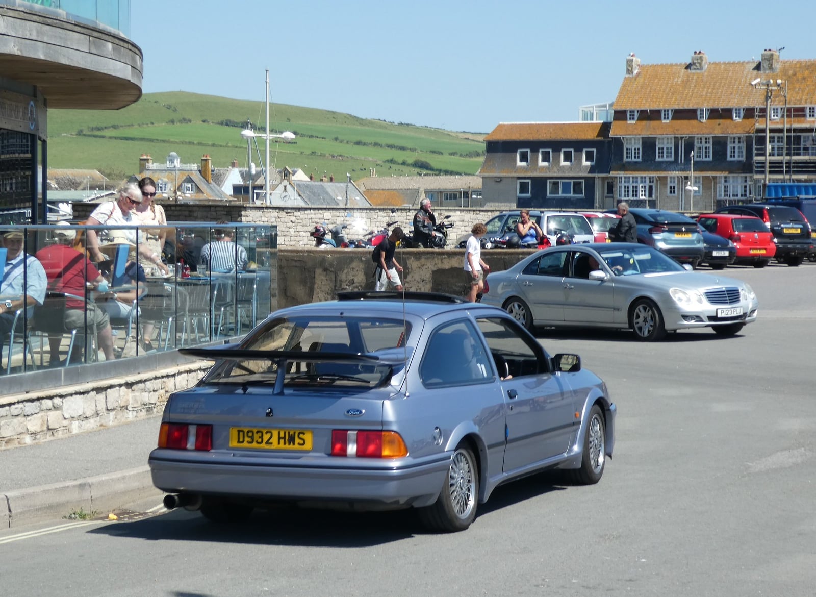 A black three-door Ford Sierra RS Cosworth, side view by the sea