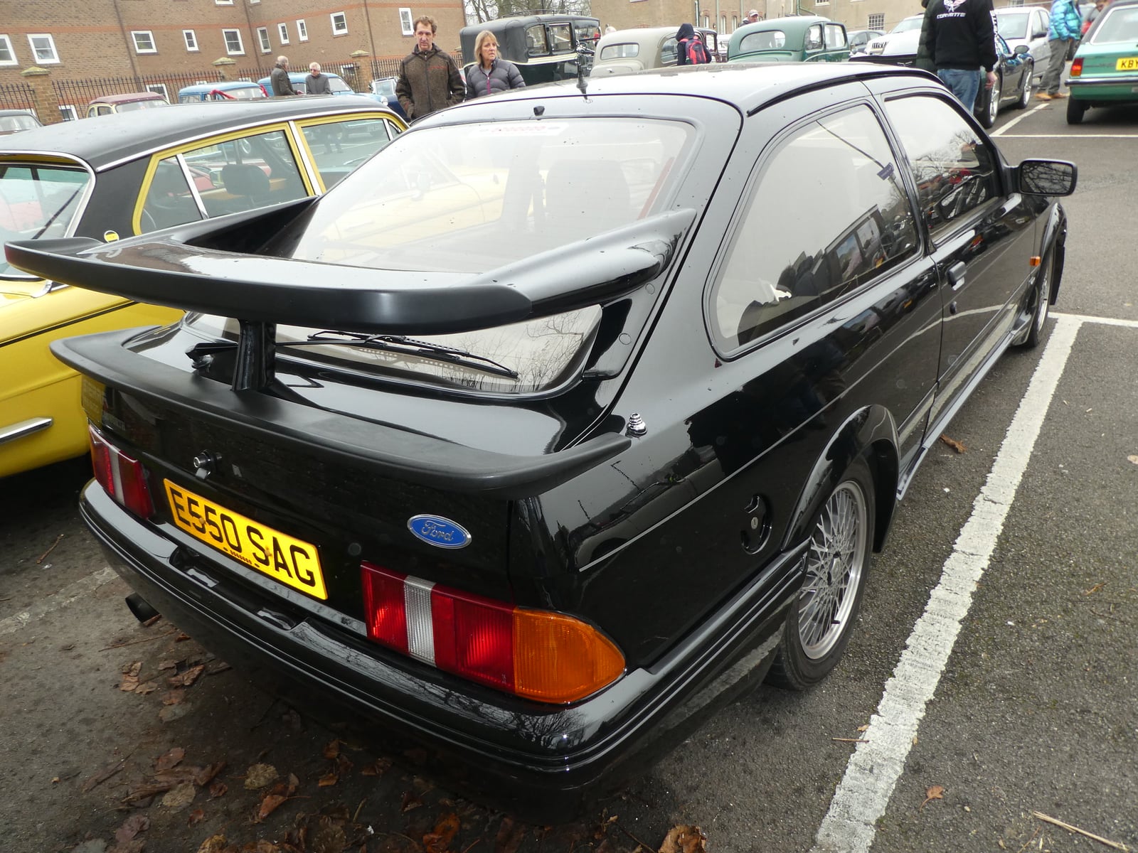 The rear of a black Ford Sierra RS500 Cosworth, showing its tall bi-plane rear wing