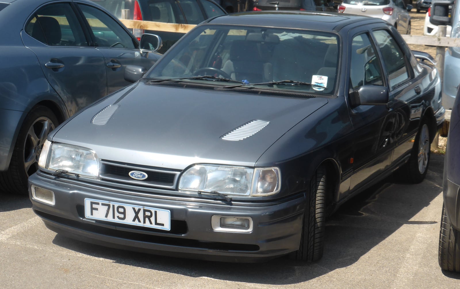 A charcoal four-door Ford Sierra Sapphire RS Cosworth, front three-quarter view