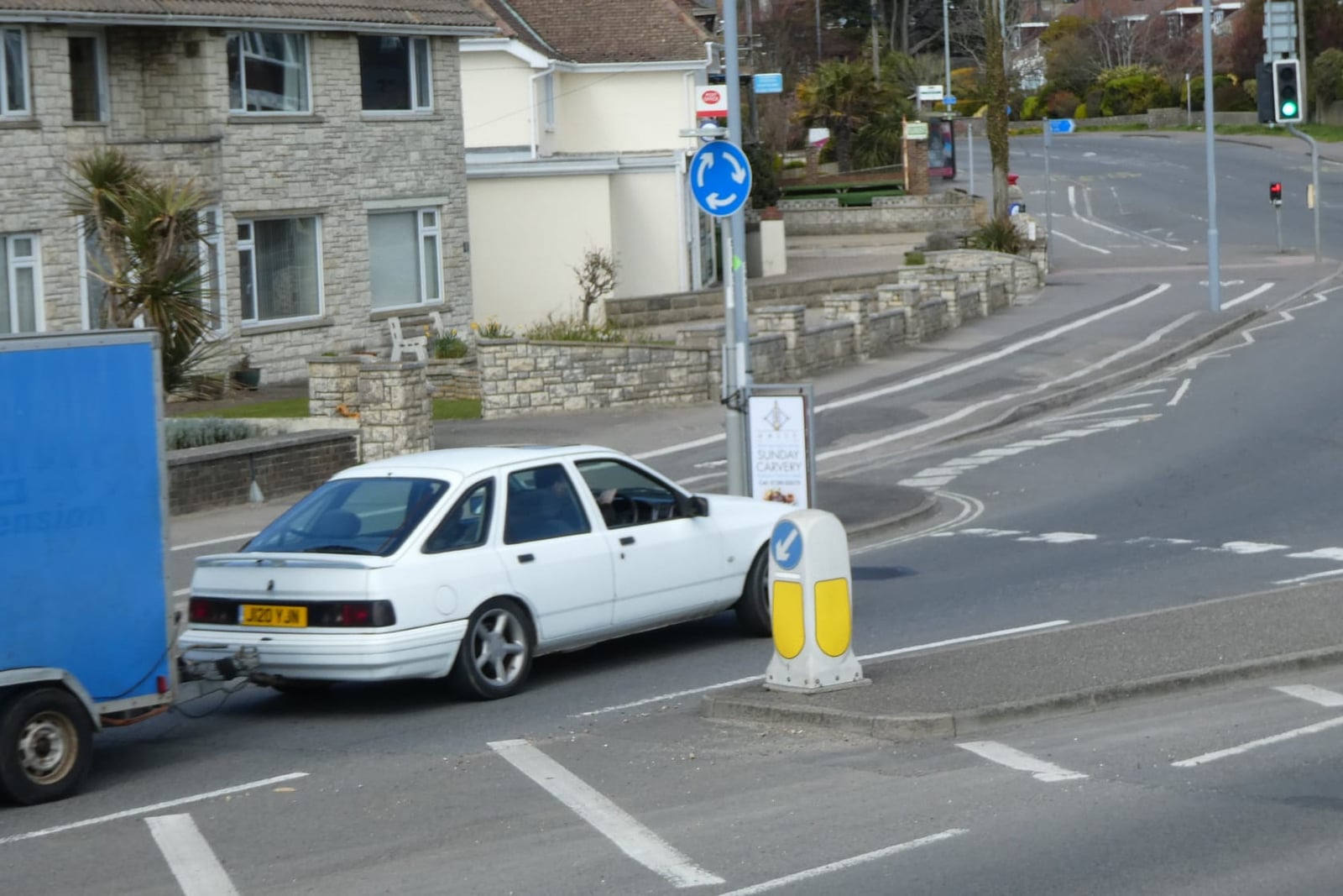 A white Ford Sierra XR4x4 parked near a road junction, front three-quarter view