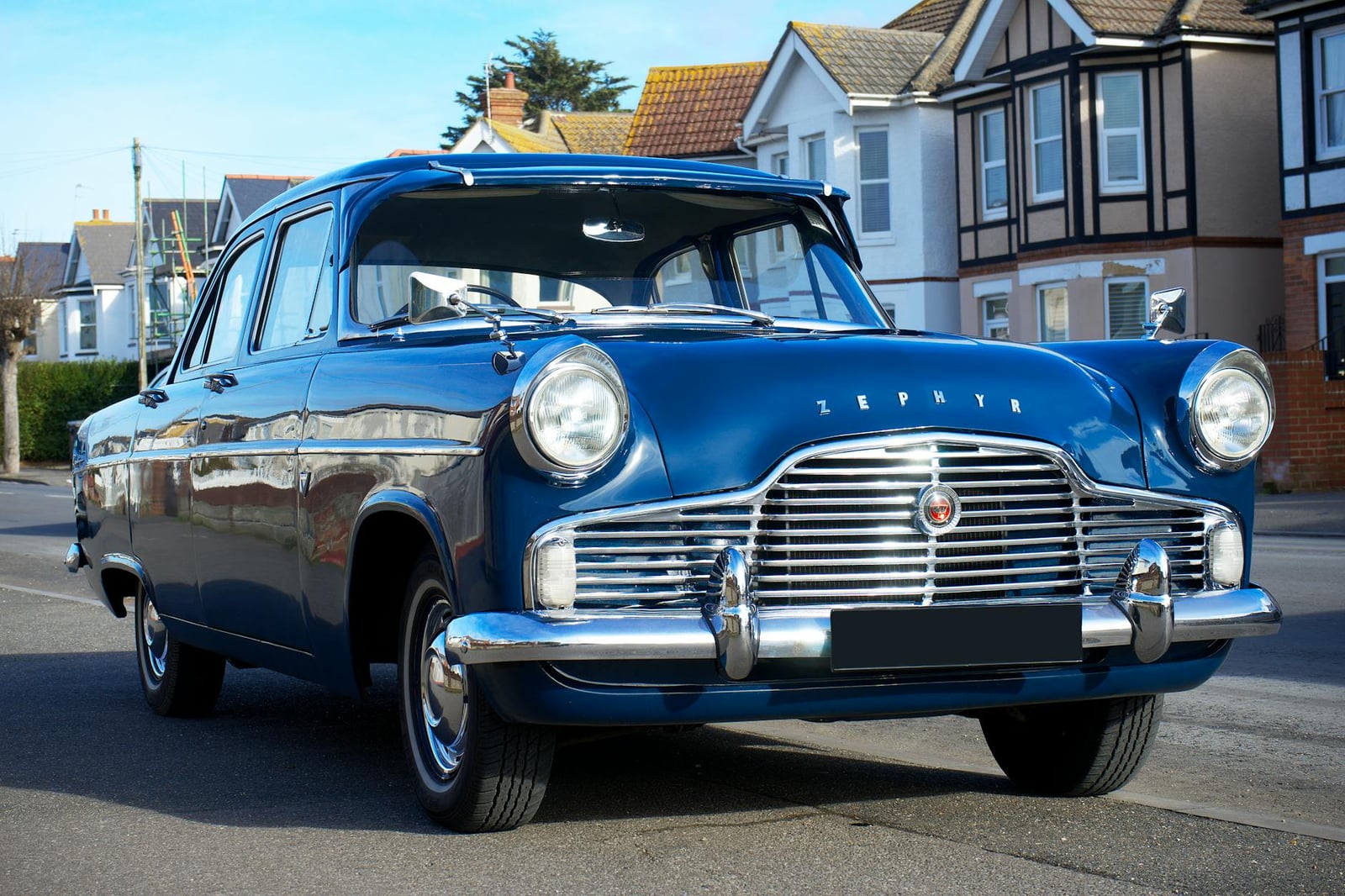 A dark blue Ford Zephyr Mk2 on a suburban street, front three-quarter view