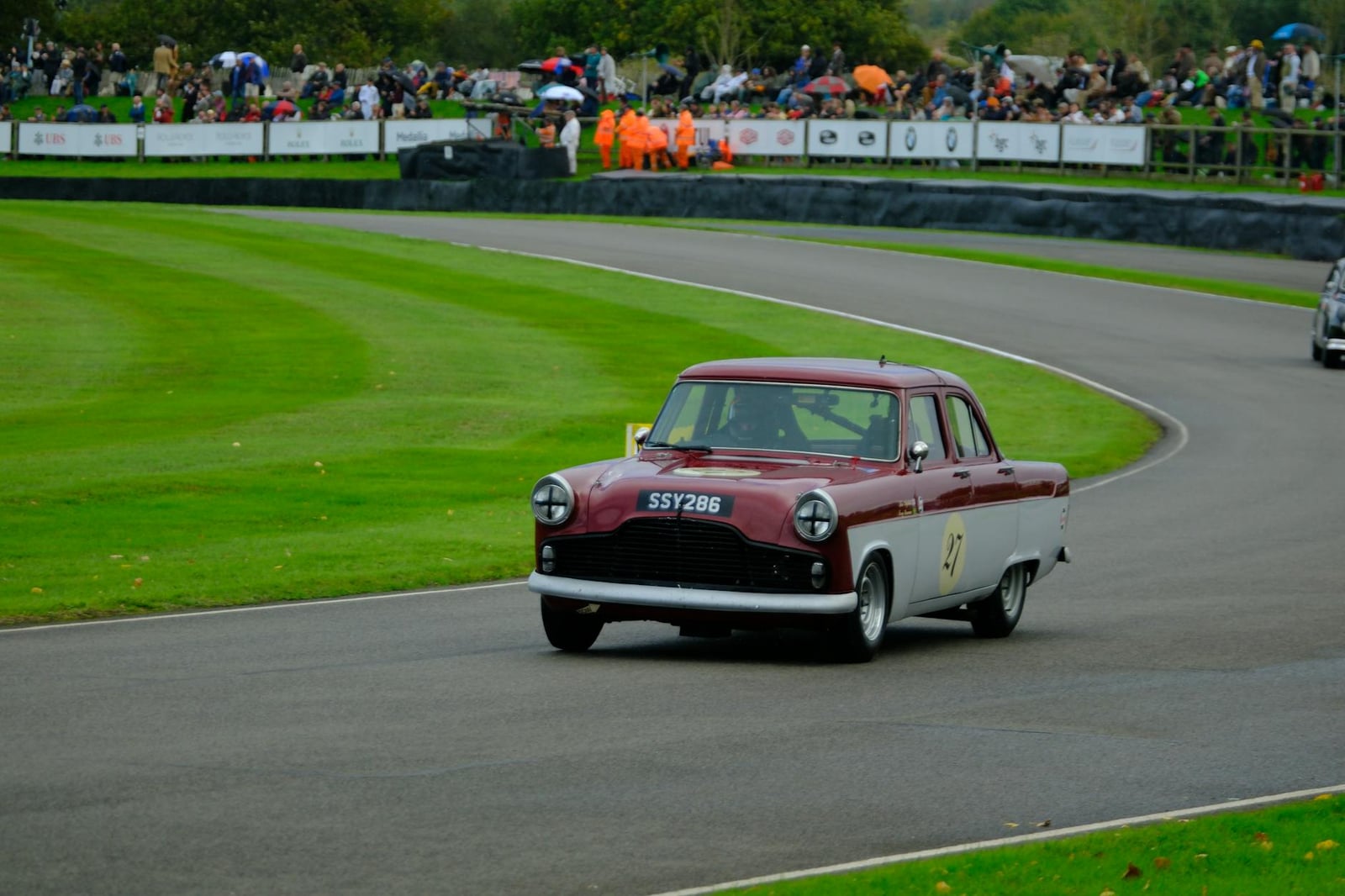 A maroon Ford Zephyr Mk2 racing on a circuit