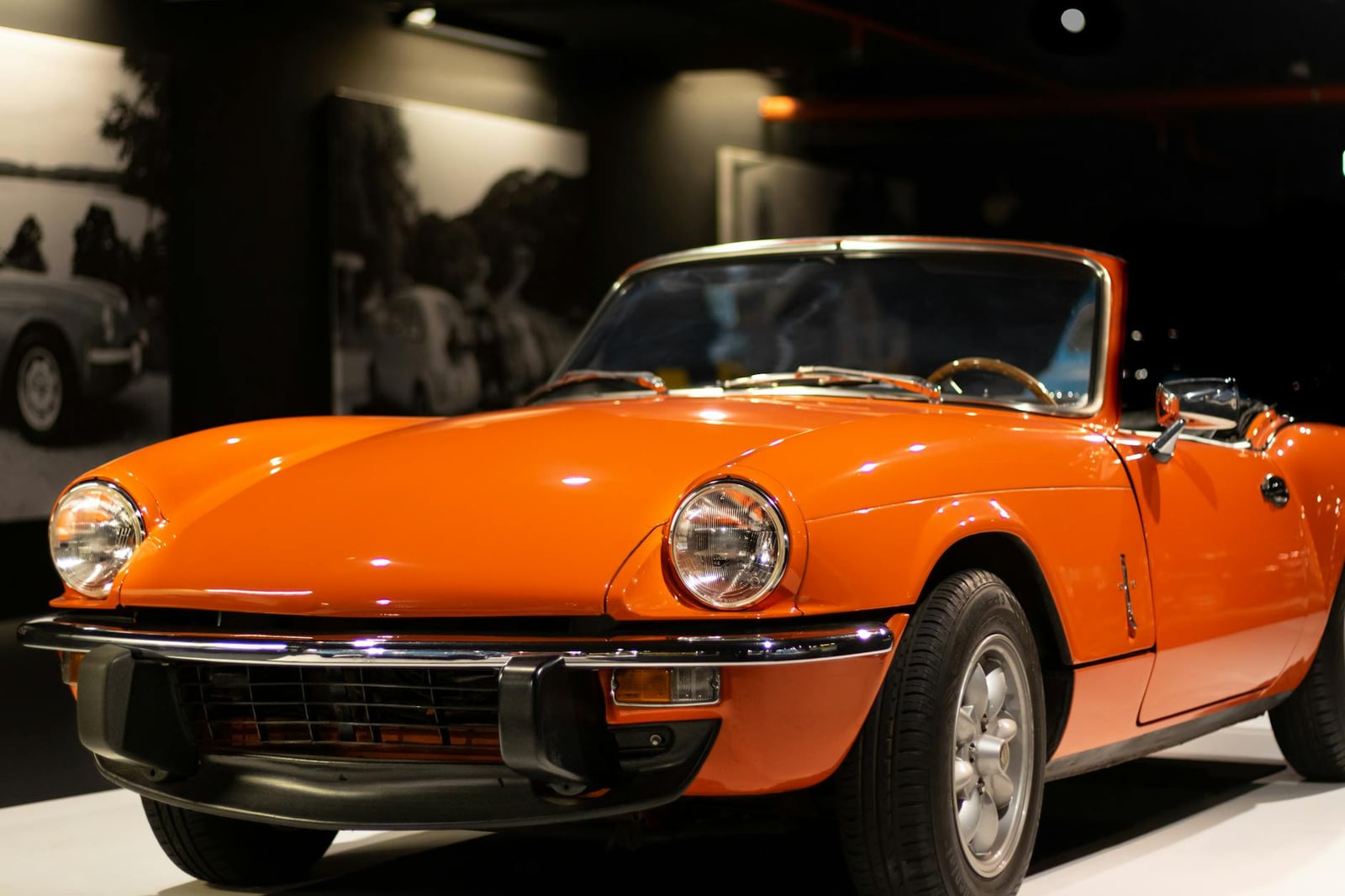 An orange Triumph Spitfire convertible, front three-quarter view