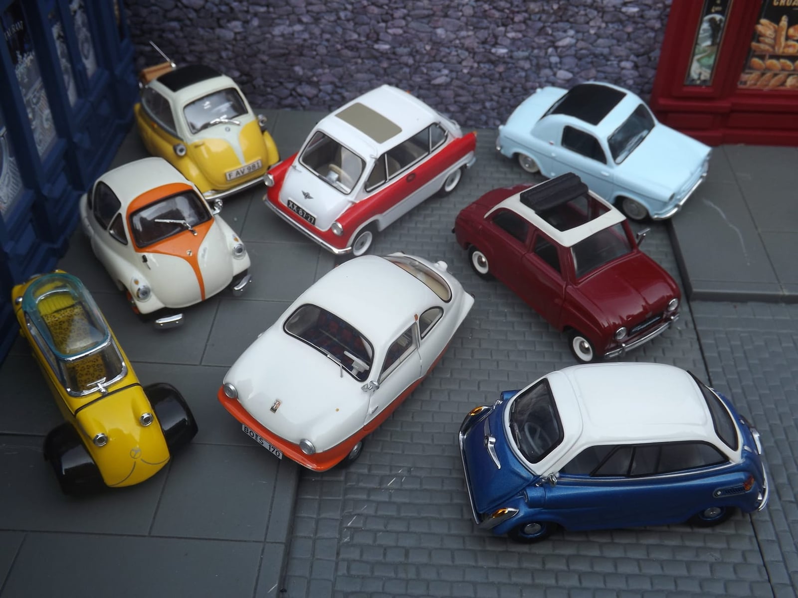 A collection of microcars including Messerschmitts, Isettas and a Heinkel on indoor museum display