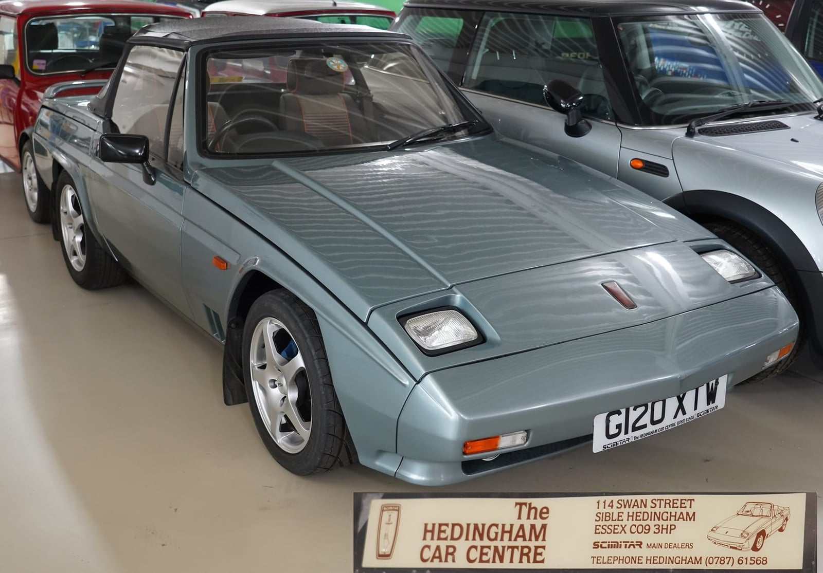 A silver-green late Reliant Scimitar in a showroom, front three-quarter view, UK registration G120 XTW