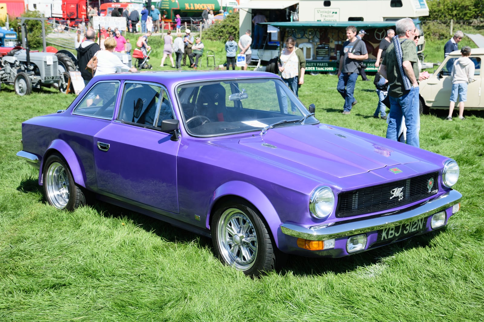 A metallic purple Gilbern Invader Mk III coupe with flared wheel arches, front three-quarter view on grass