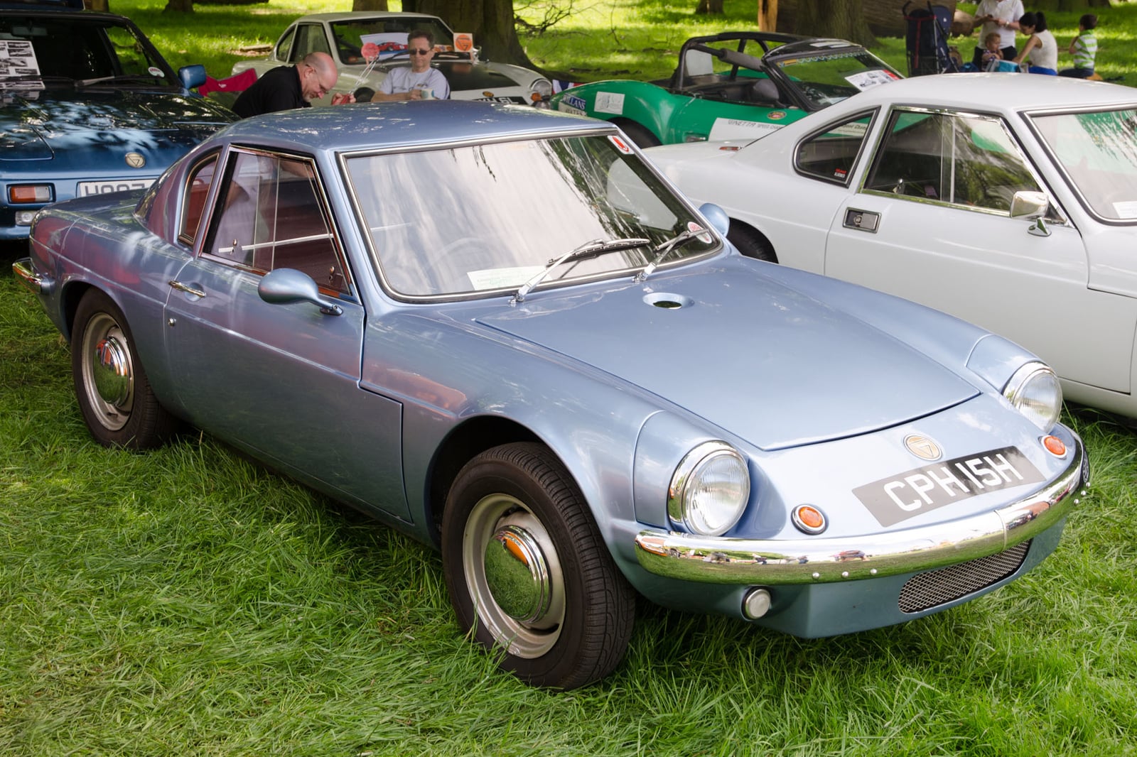 A silver-grey Ginetta G15 coupe, front three-quarter view on grass at a classic car show