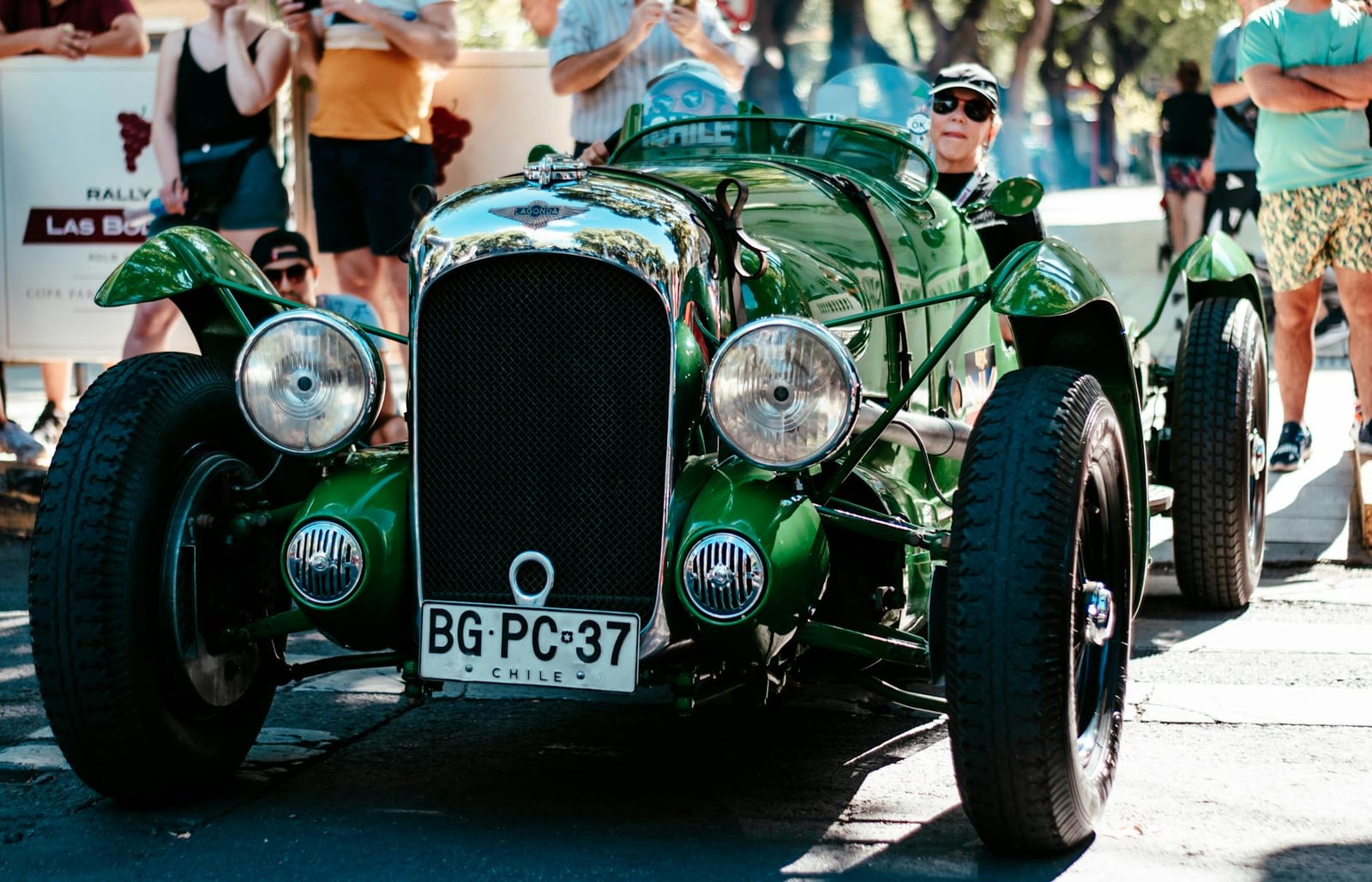 A green pre-war Lagonda tourer on a rally, front view