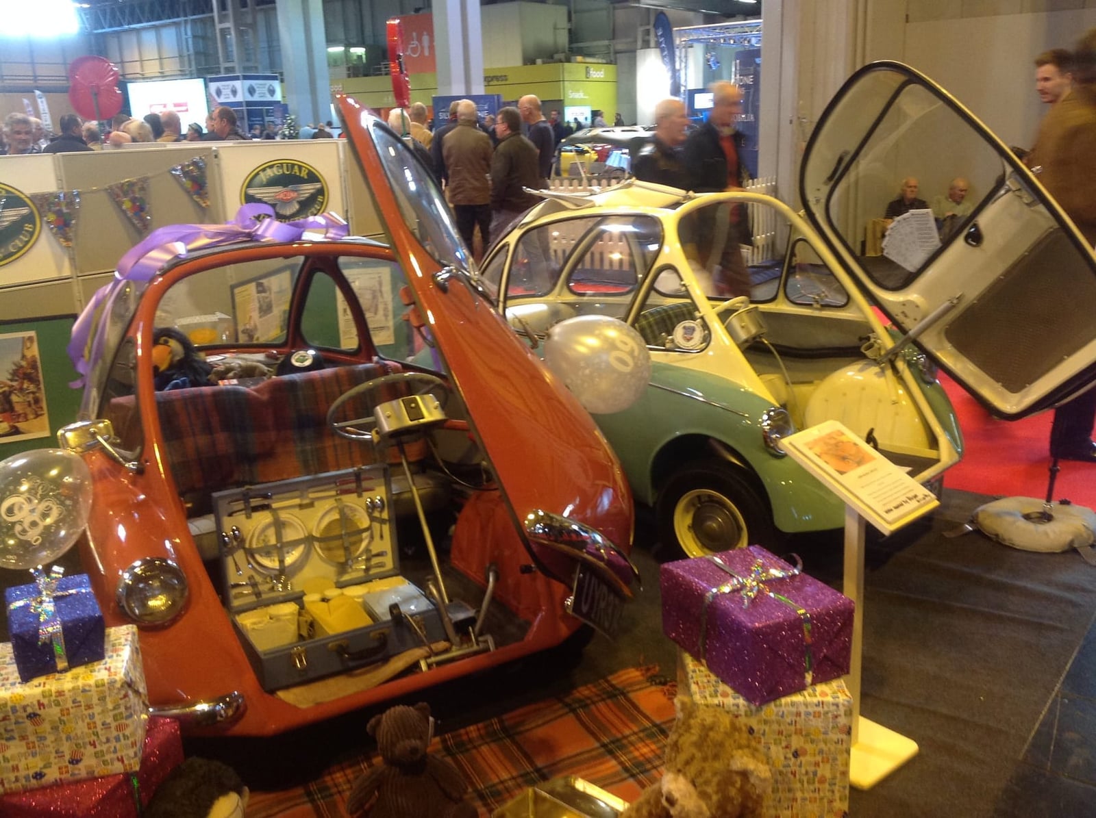 A red Trojan-built Heinkel bubble car on grass at a classic vehicle show, front view, UK registration 566 LJH