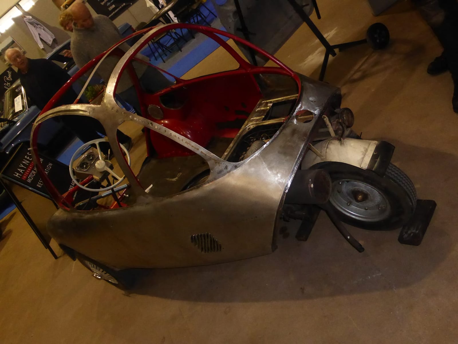 A bare Heinkel bubble car shell under restoration in a workshop