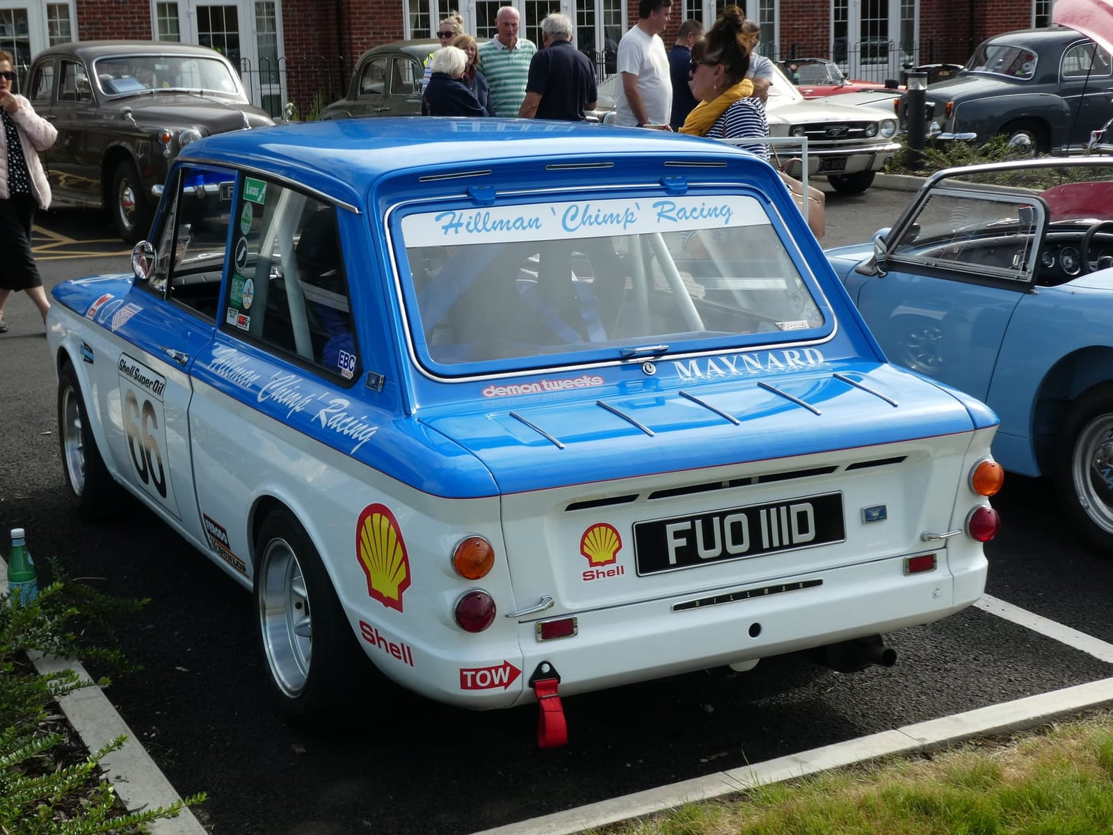 A blue and white Hillman Imp race car with sponsor decals, rear three-quarter view