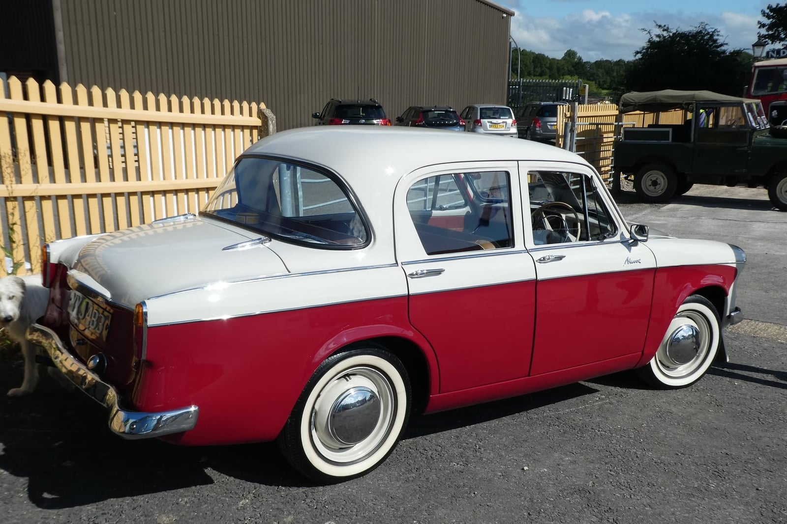 A white and red two-tone Hillman Minx Series III seen from the side and rear