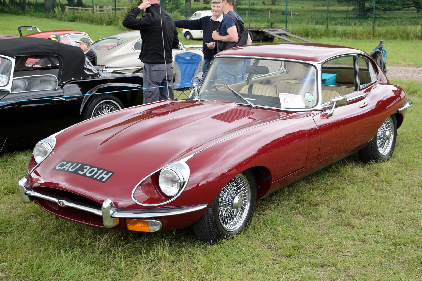 A maroon Jaguar E-Type Series 2 2+2 coupe at a show, front three-quarter view