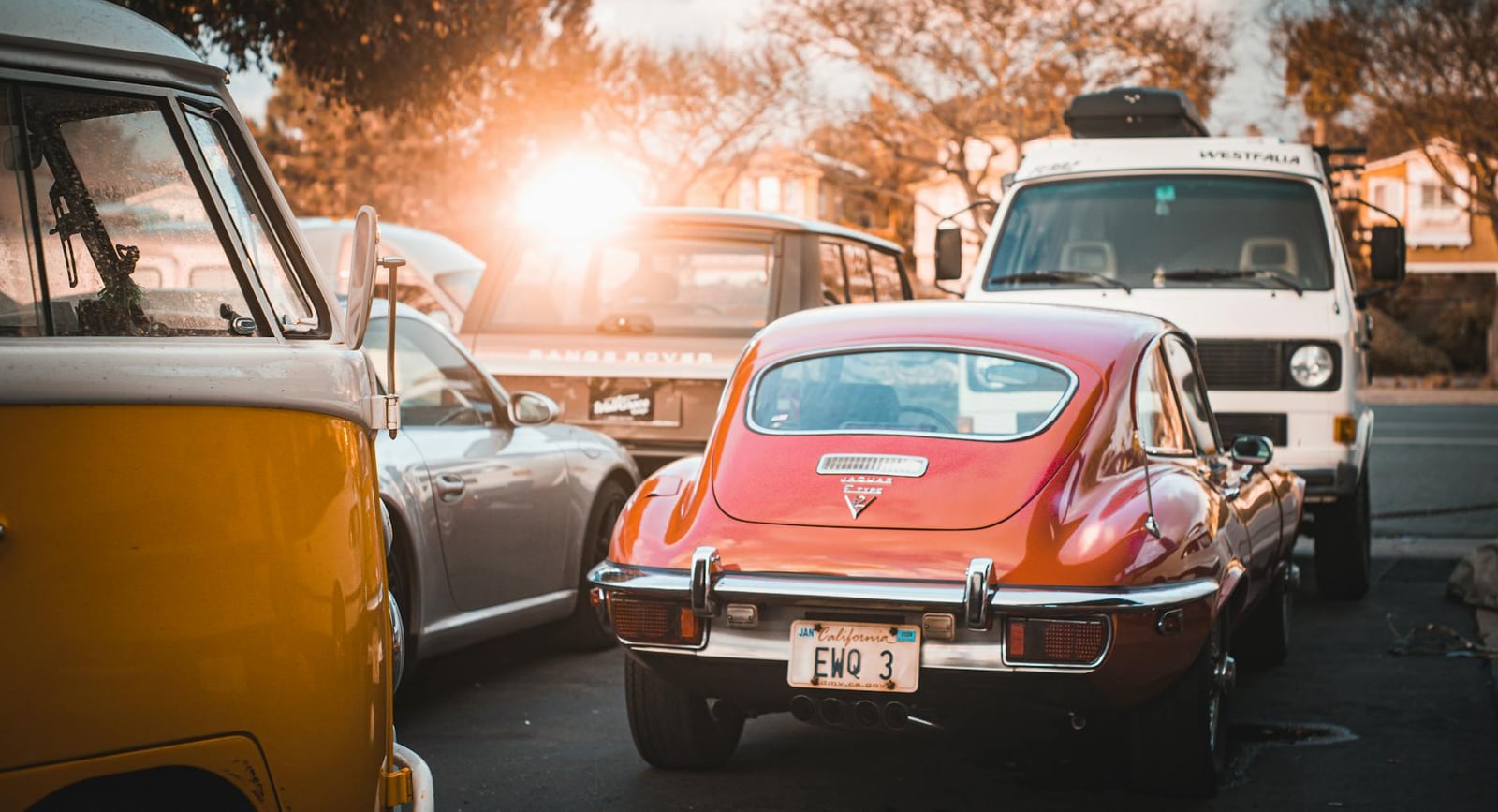 Rear of a red Jaguar E-Type Series 3 V12 2+2 coupe at sunset, showing the V12 badge