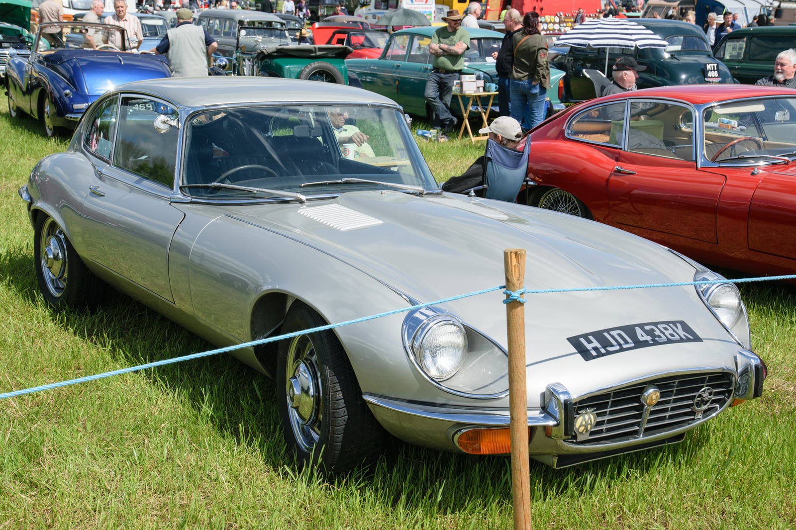 A silver Jaguar E-Type Series 3 V12 2+2 coupe parked on grass