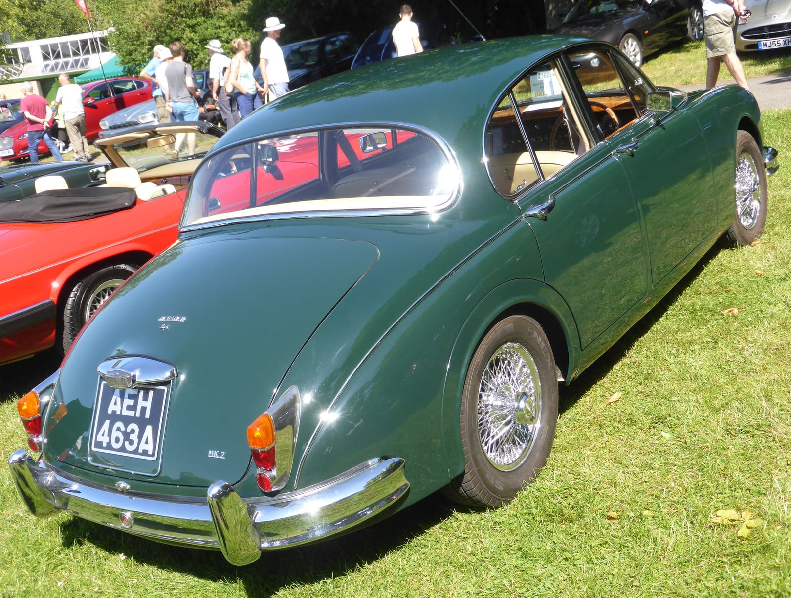 A green Jaguar Mk2 saloon with wire wheels, rear three-quarter view