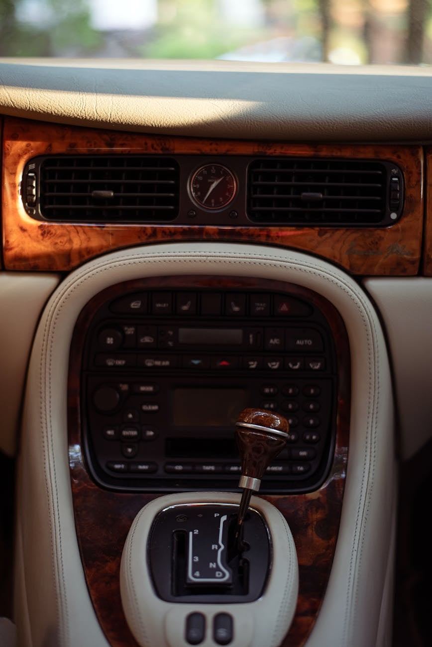 Close-up of a Jaguar XJ interior showing the burl walnut centre console and the J-gate automatic selector