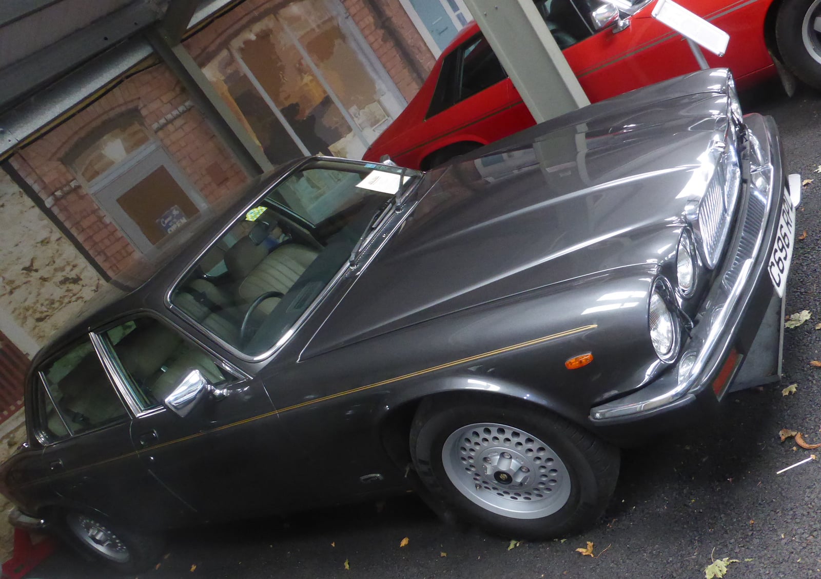 A dark Jaguar XJ6 Series 3 Sovereign saloon on a cobbled street, front three-quarter view