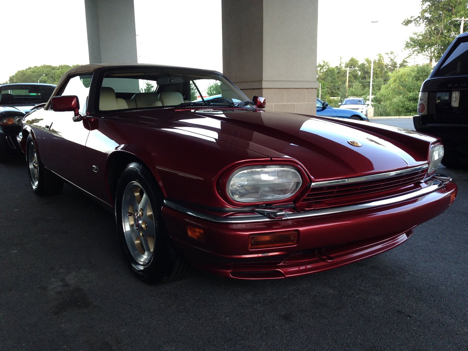A maroon Jaguar XJS V12 convertible with lattice alloy wheels, front three-quarter view