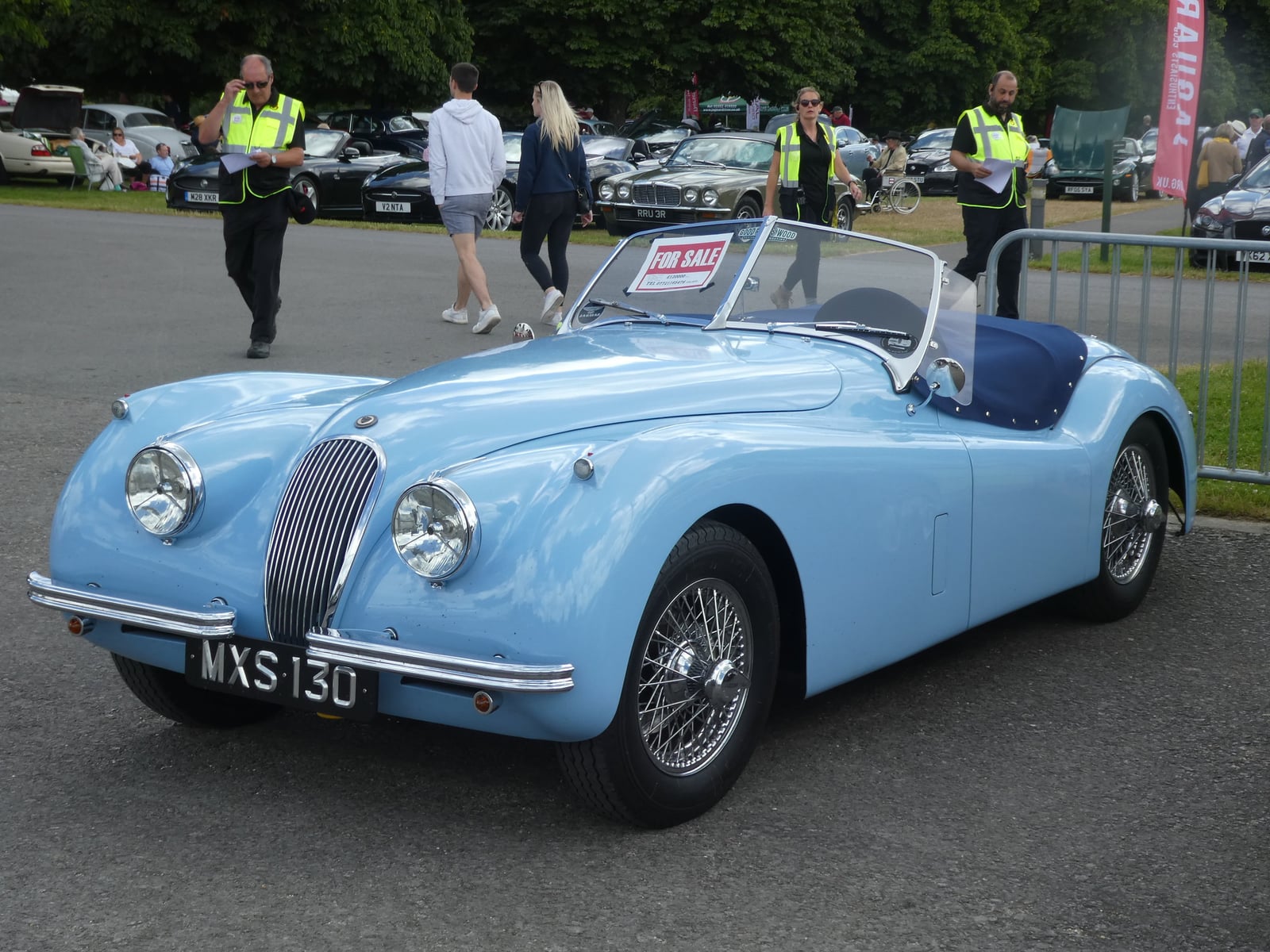 A pale blue Jaguar XK120 open roadster, front three-quarter view at a classic car show, UK registration MXS 130