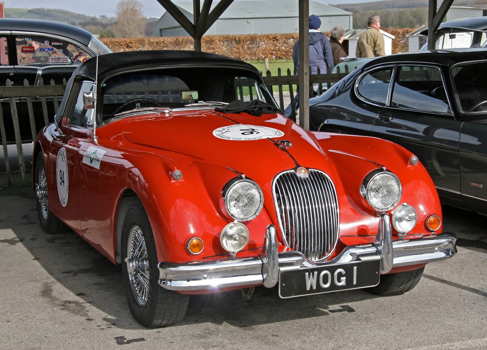 A red Jaguar XK150 in rally trim with competition number, front view, UK registration WOG 1