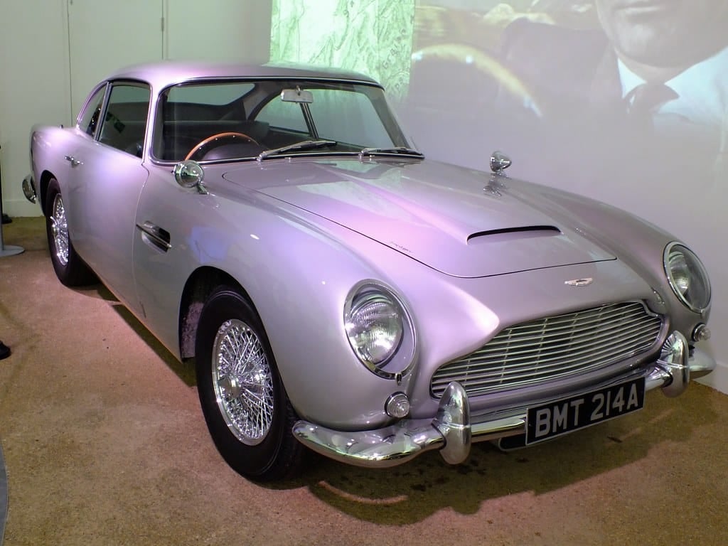 A silver birch Aston Martin DB5 with BMT 214A registration displayed in a museum Bond exhibit